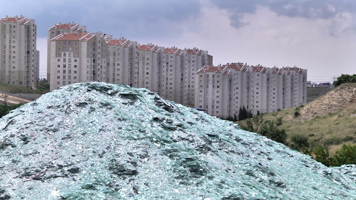 A hill with several buildings behind it.