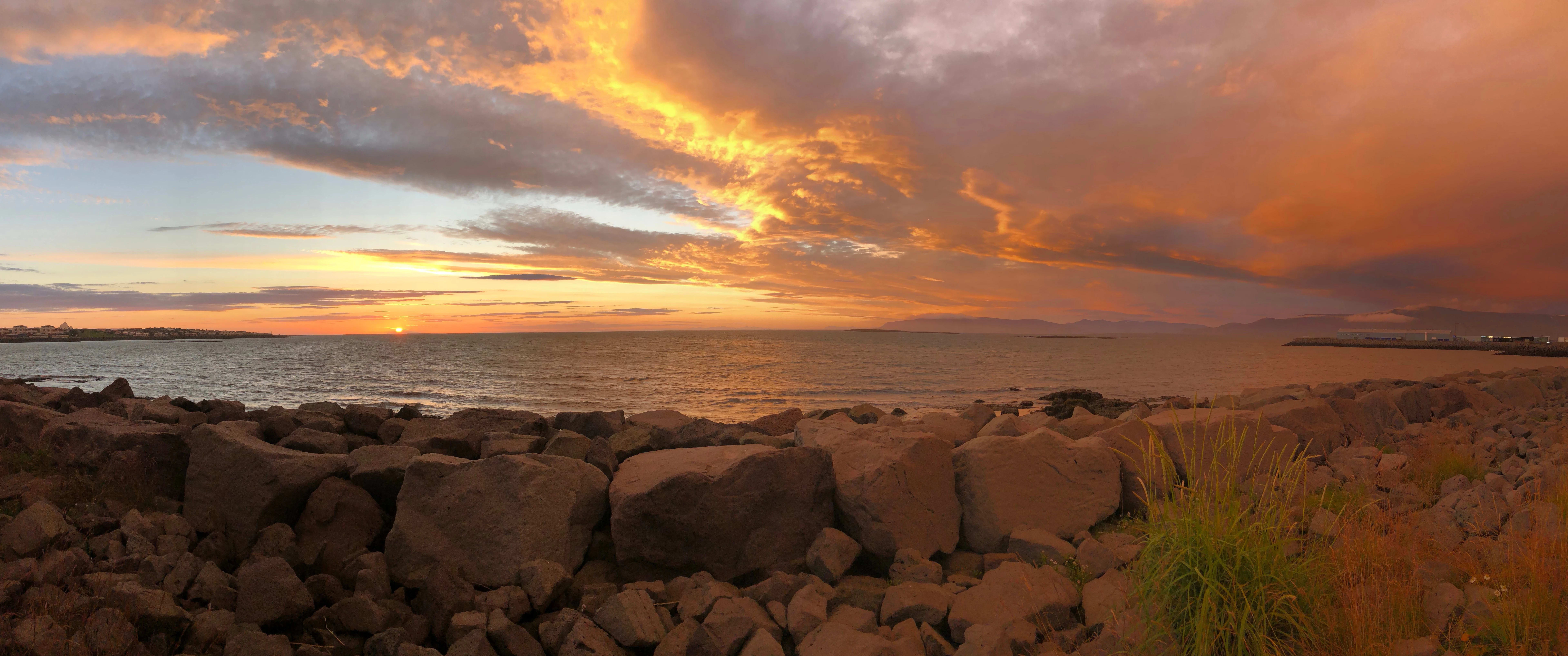 rocks in front of ocean with orange sky