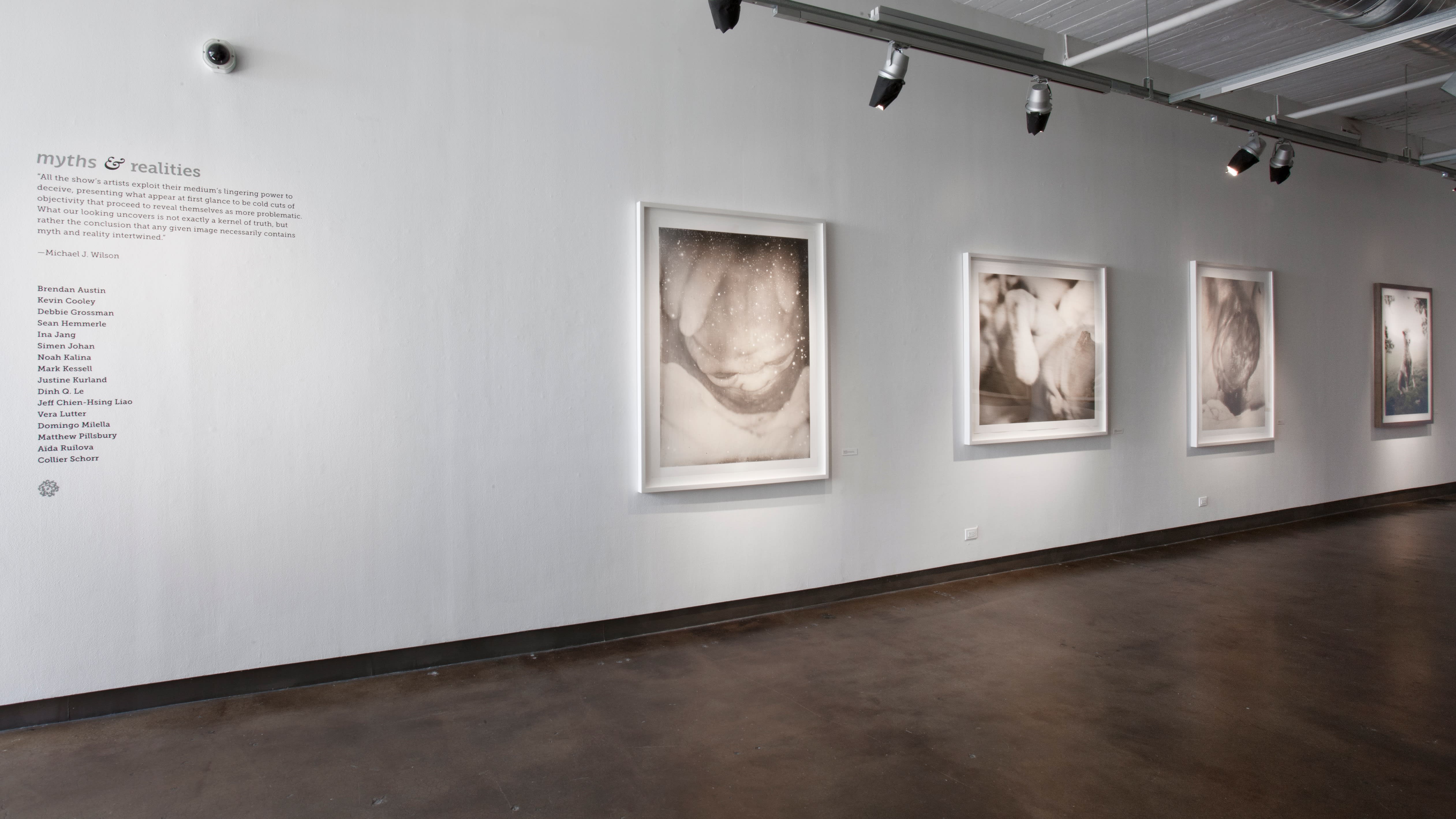 A gallery displaying black and white art. There is a description of the exhibition on the wall.