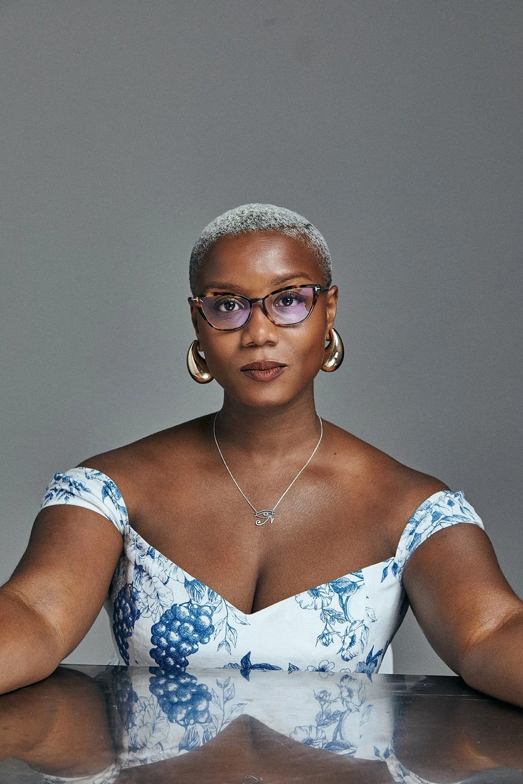Portrait of a woman, Ja'Tovia Gary, posing in front of a reflective table. 