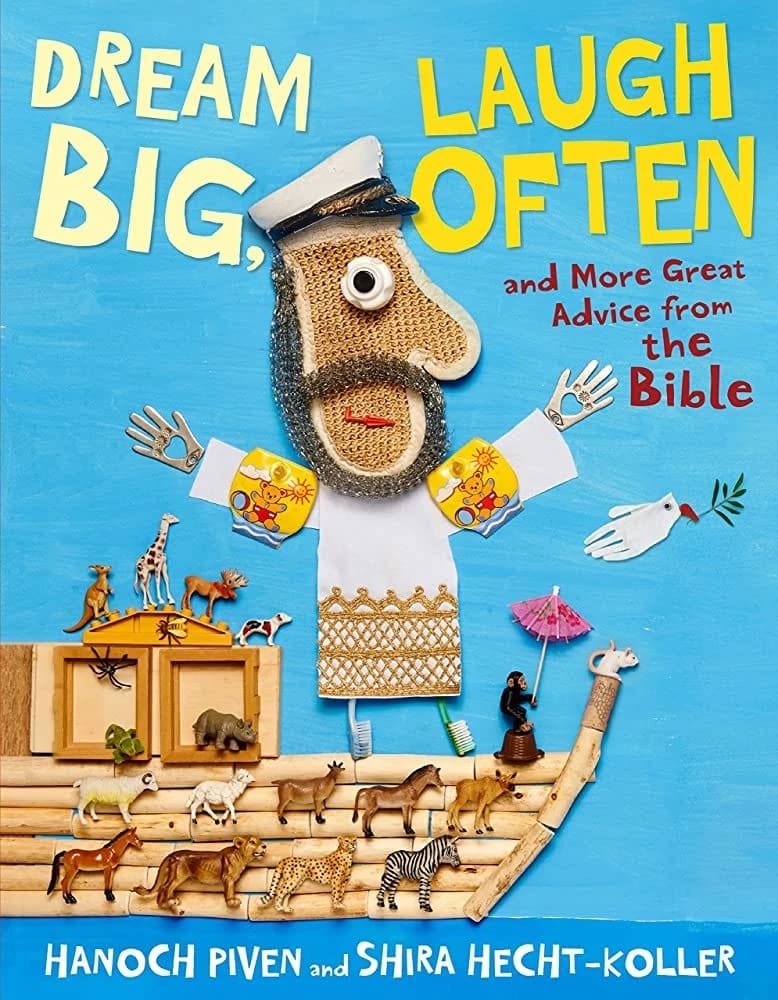 A book cover of "Dream Big Laugh Often" with a man figure on standing on a boat with his arms outstretched. He is made out of a collage of various objects, including an oven mitt for his face and toothbrushes for his feet. On the boat are many little plastic animals. 