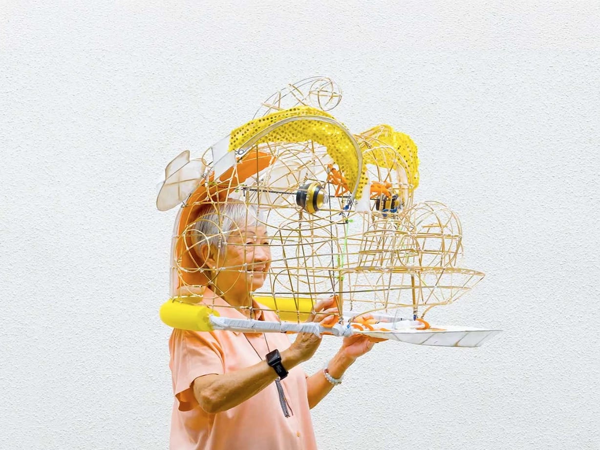 an old person holding a wire dragon head sculpture on their shoulders