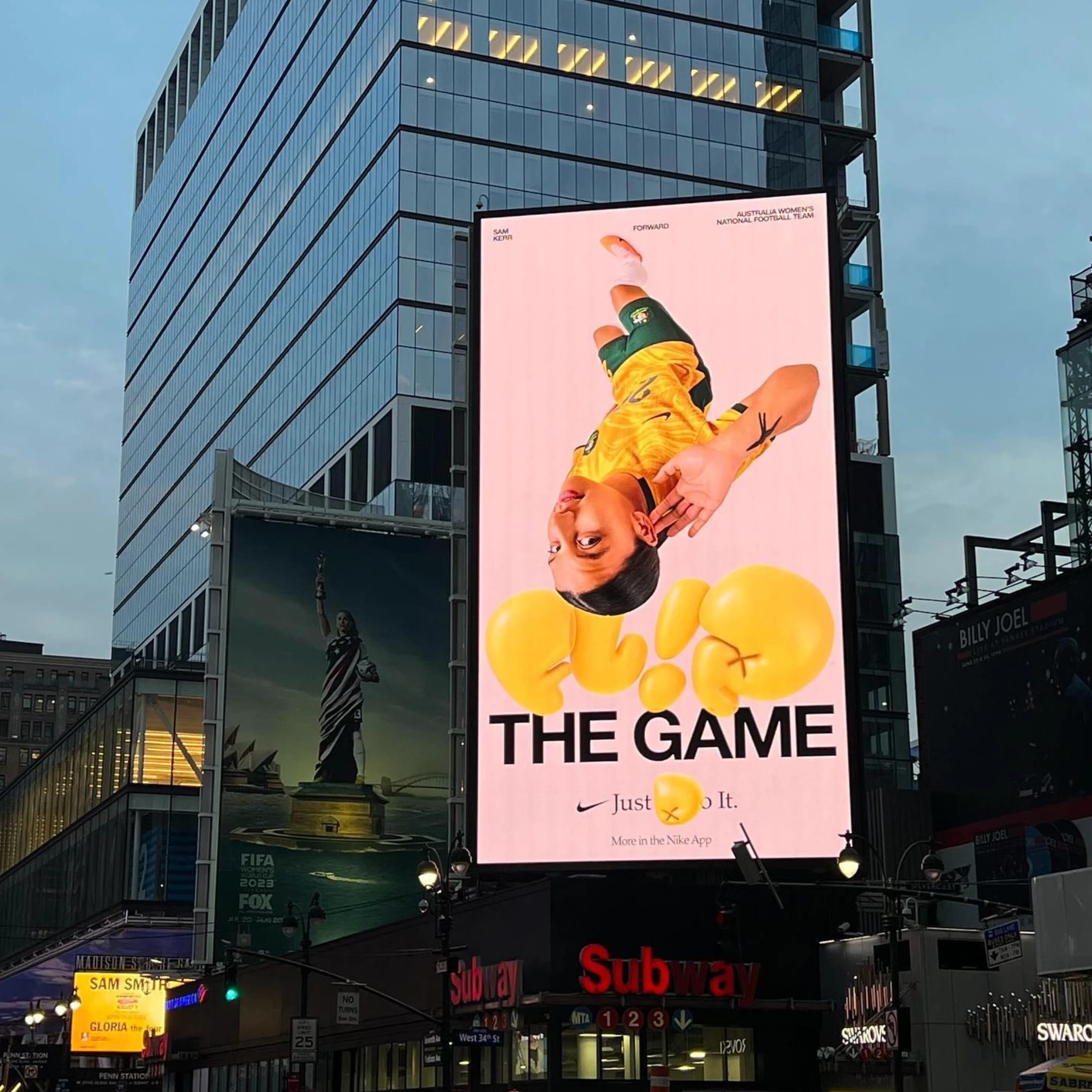 A billboard of a woman on a pink background in new york city