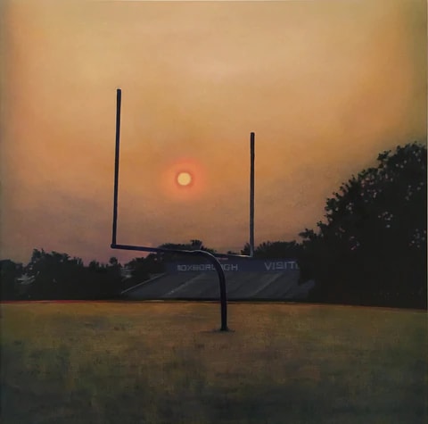 A painting of a football field at sunset, with the setting sun framed by the goal post. There is a set of bleachers in the distance. The sky is orange and the grass is a mix of green and amber.