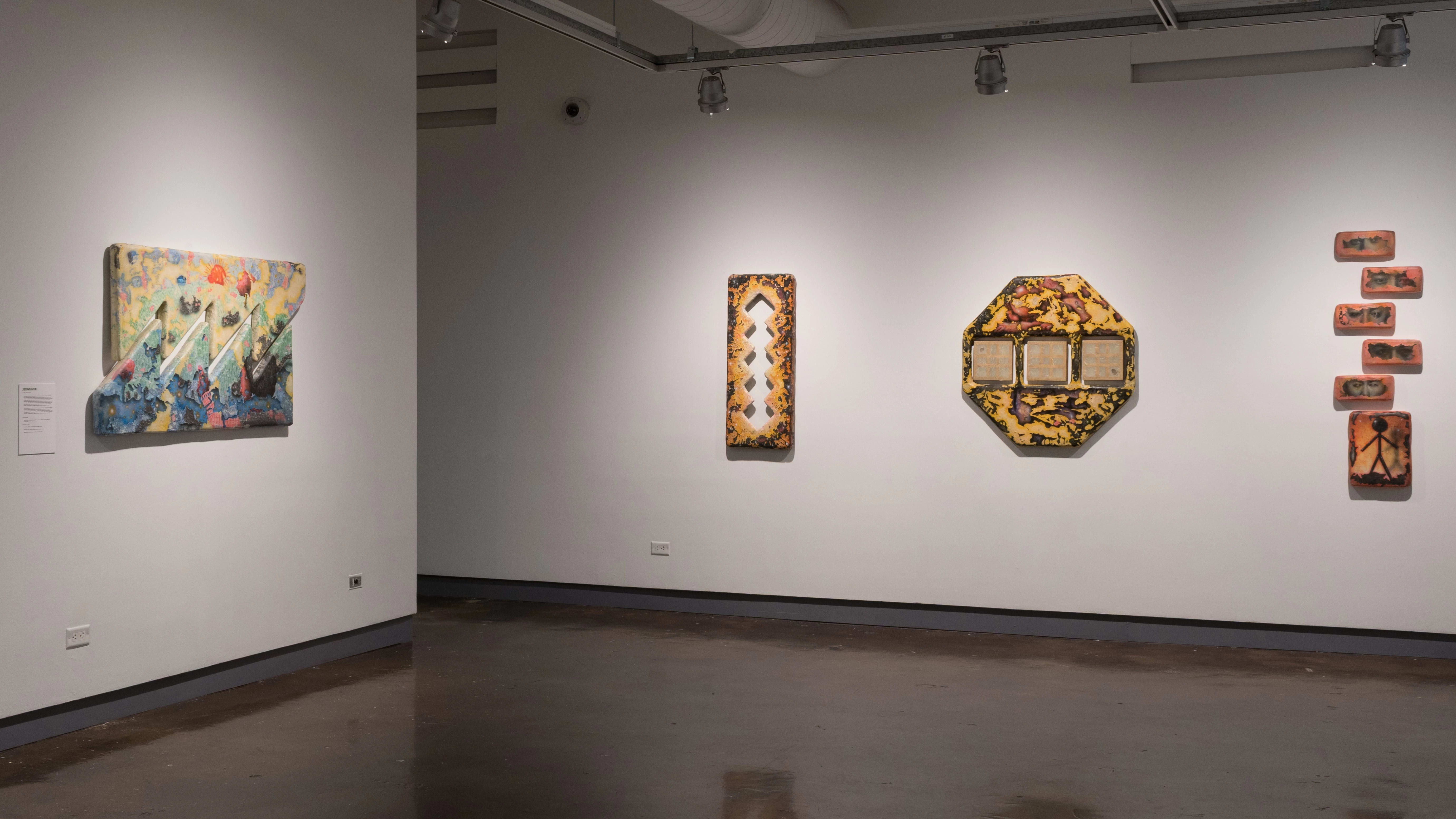 A corner of the first gallery with several mixed media artworks hung on the wall.