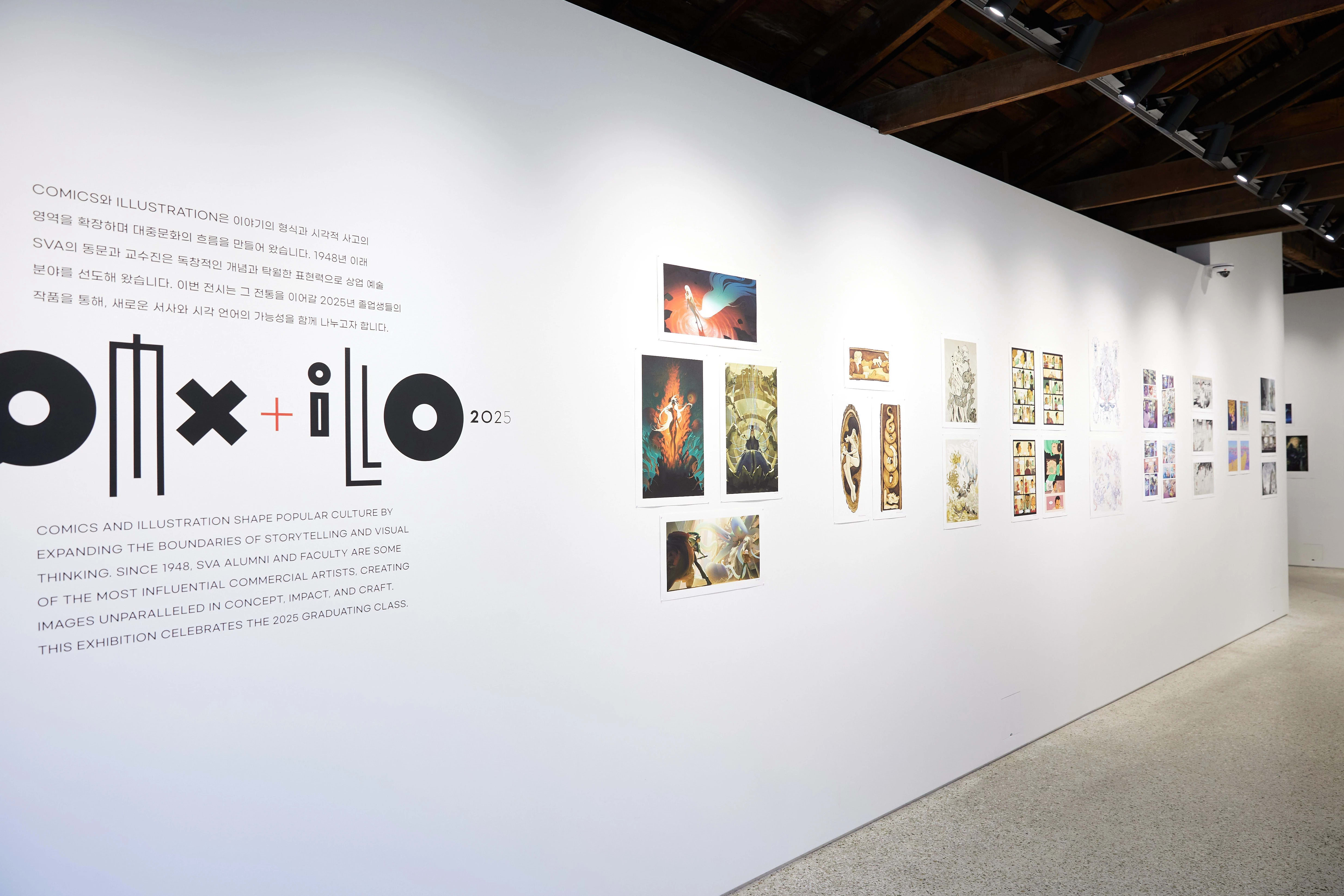 Exhibition wall featuring the “Comix + Illo 2025” show at SVA Seoul Gallery. The left wall displays the exhibition title and bilingual introduction text in bold typography, while the adjacent wall showcases a series of colorful illustration and comic artworks arranged in a linear sequence under track lighting within a wooden-beam ceiling space.