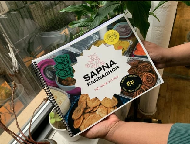 Hands holding colorful cookbook