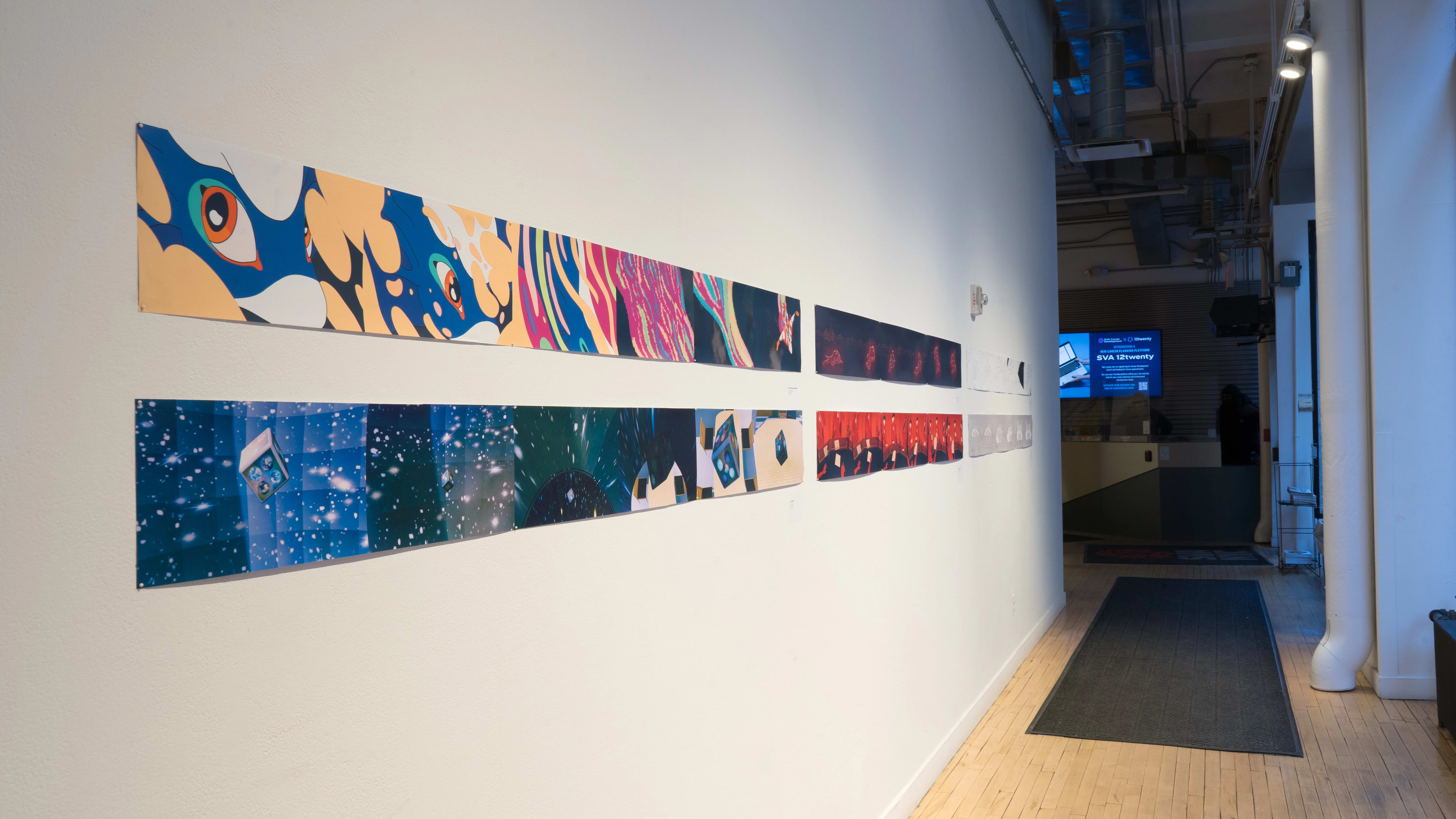 An angled shot of the SVA Flatiron Gallery Windows looking east, showing many colorful prints by BFA Animation students pinned up. A monitor plays reels over the security desk in the far background.