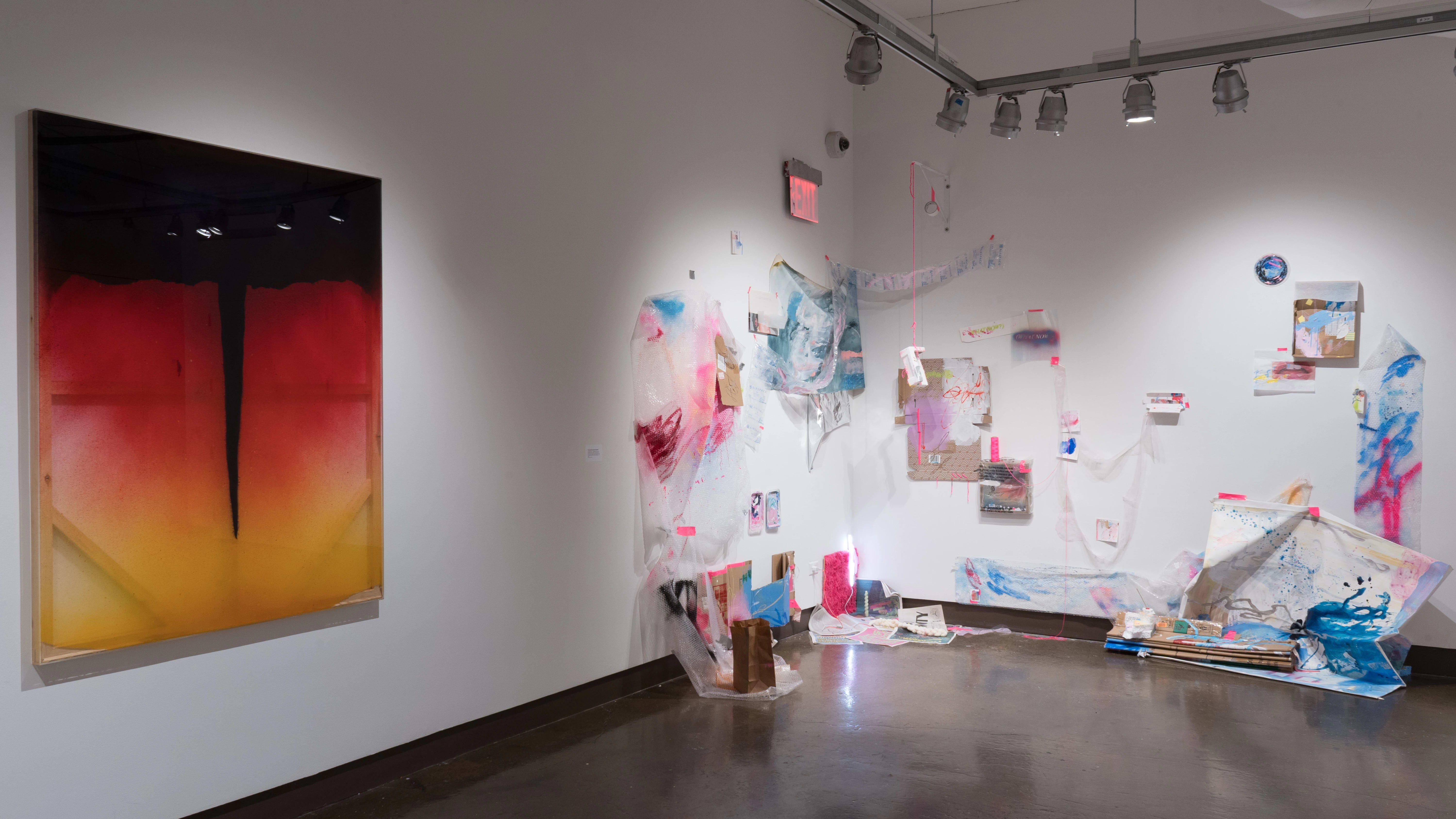 In the corner next to the cat-eye-like paintings, another installation uses detritus such as paper, cardboard, packing materials, and takeout bags as decorations to create a space dashed with blue and pink paint.