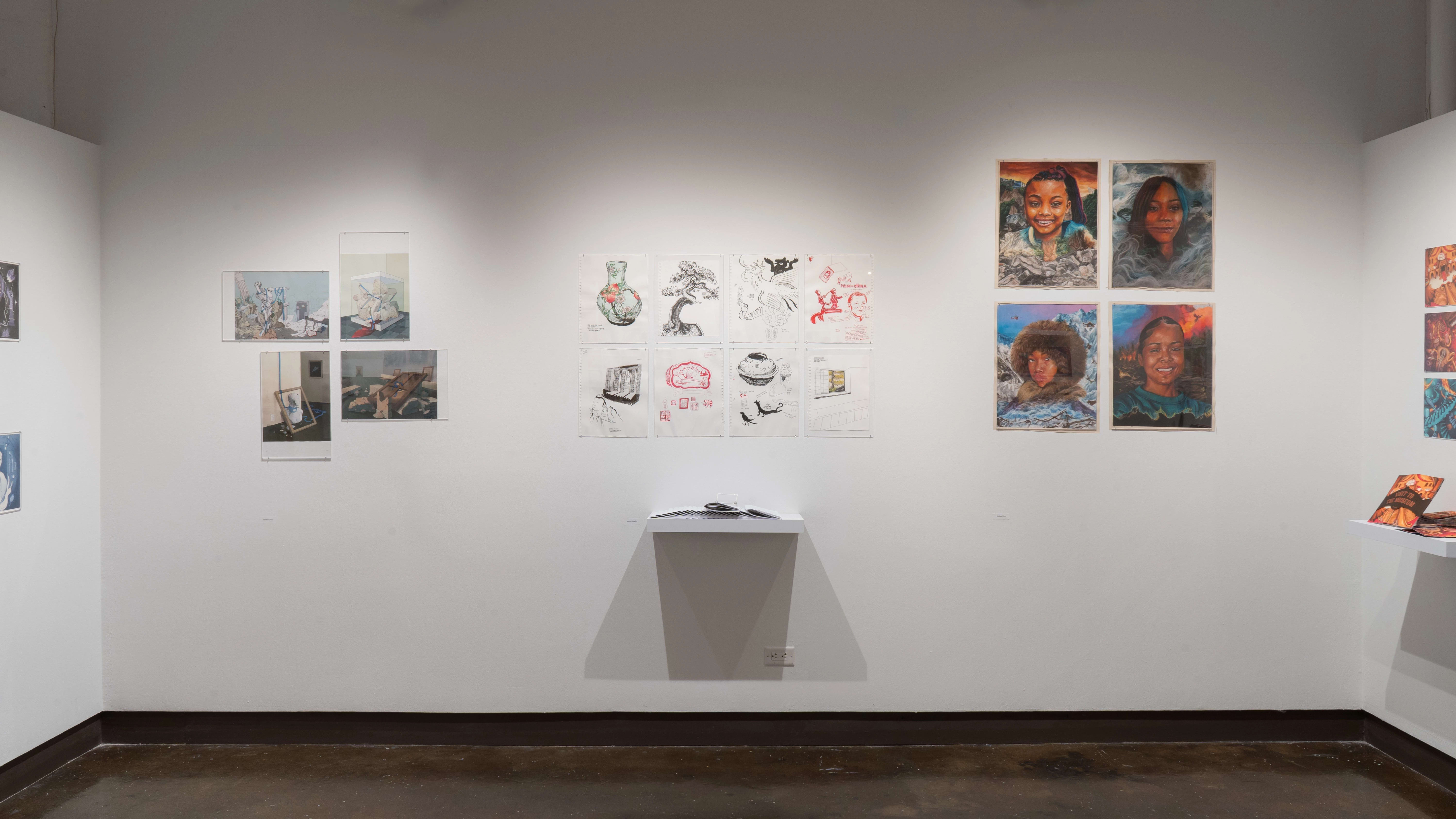 aIn the center of the gallery four alcove, two rows of simple illustrations are hung on the wall above a shelf holding many paper zines. To the right, four portraits hang in a grid, and to the left there are four illustrations of debris and objects.