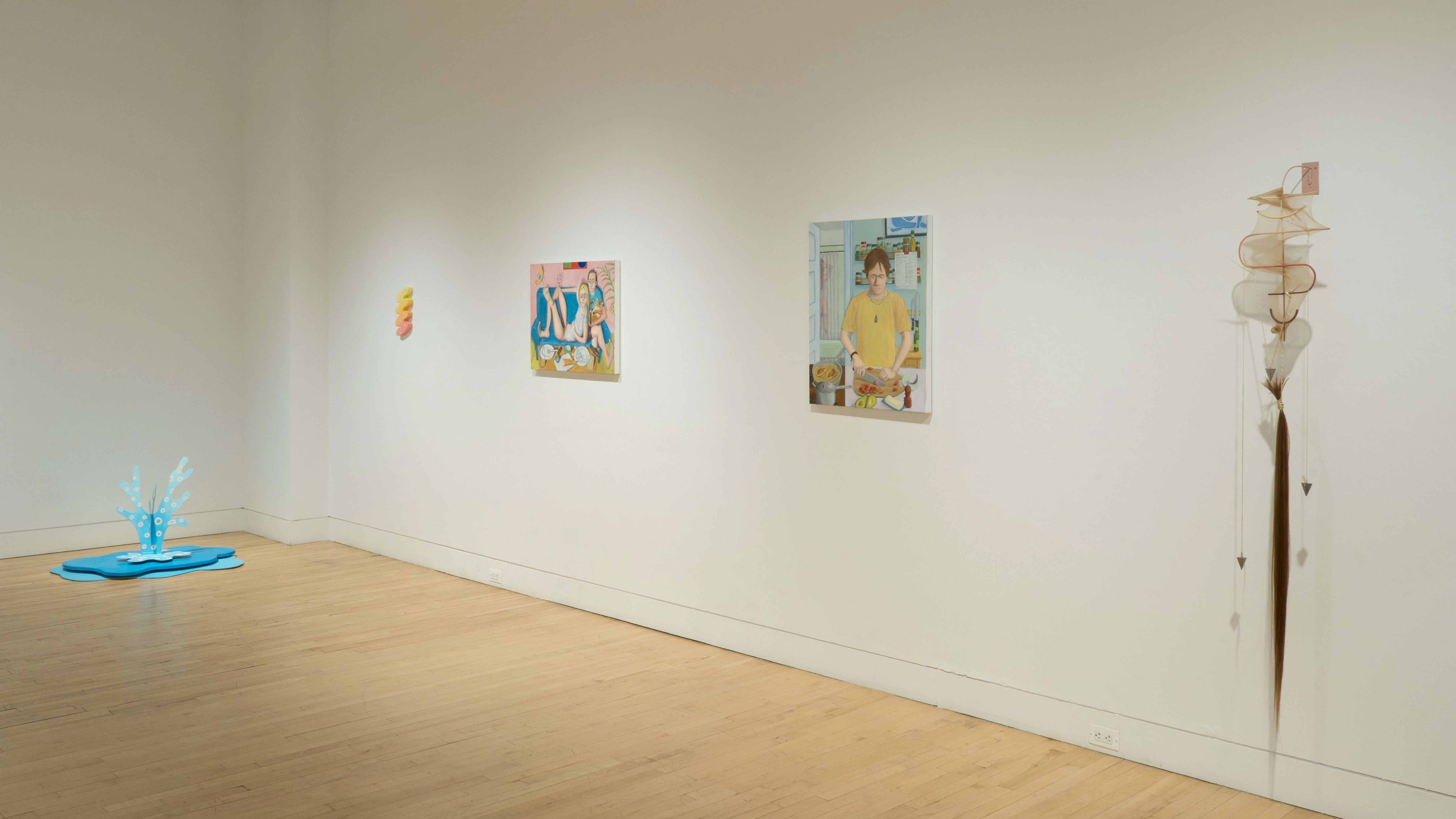 The blue fountain sculpture is visible in the corner to the left of the wall where the squiggle painting, the figurative paintings, and the abstract sculpture hang.