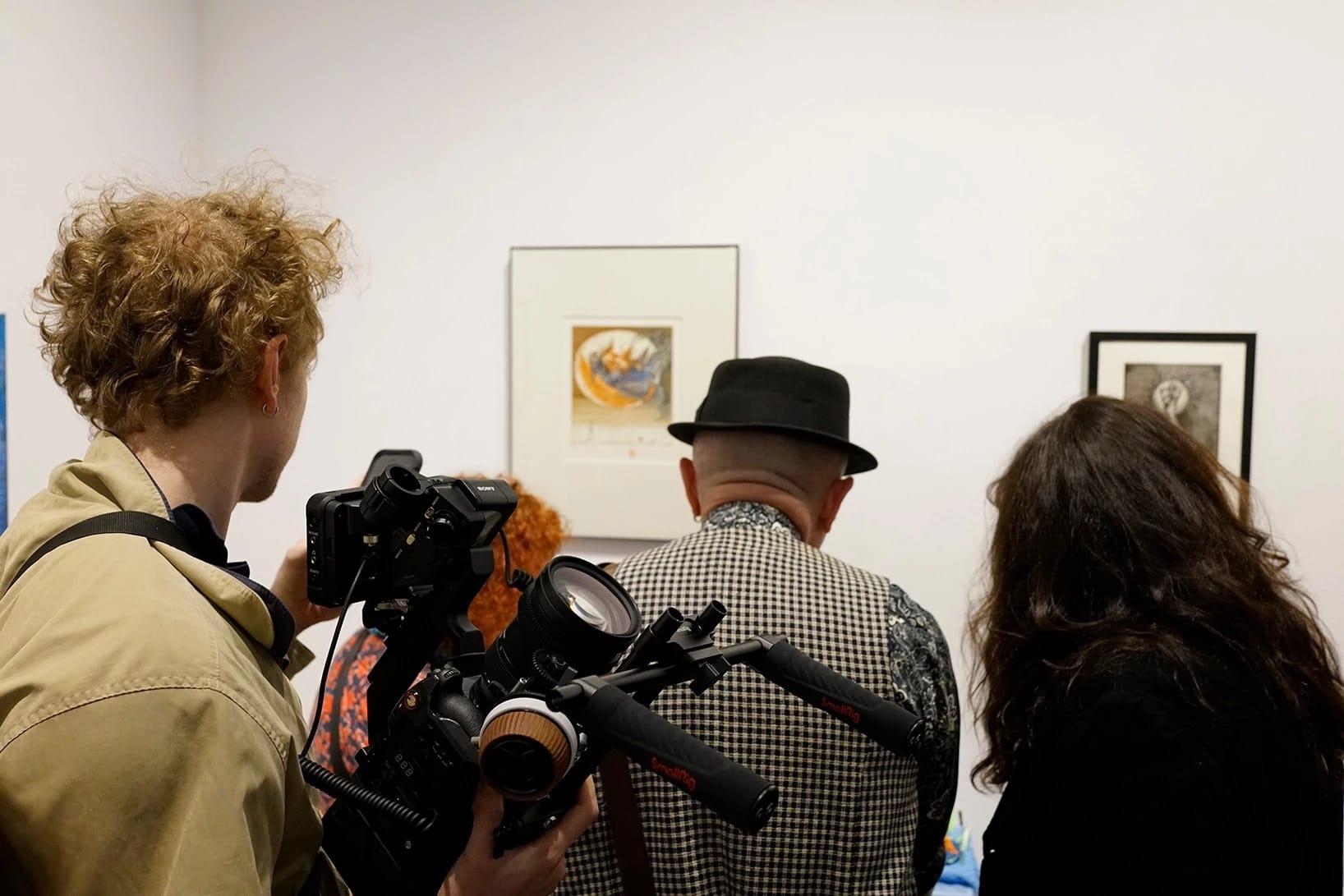Audience and a cameraman looking at an artwork