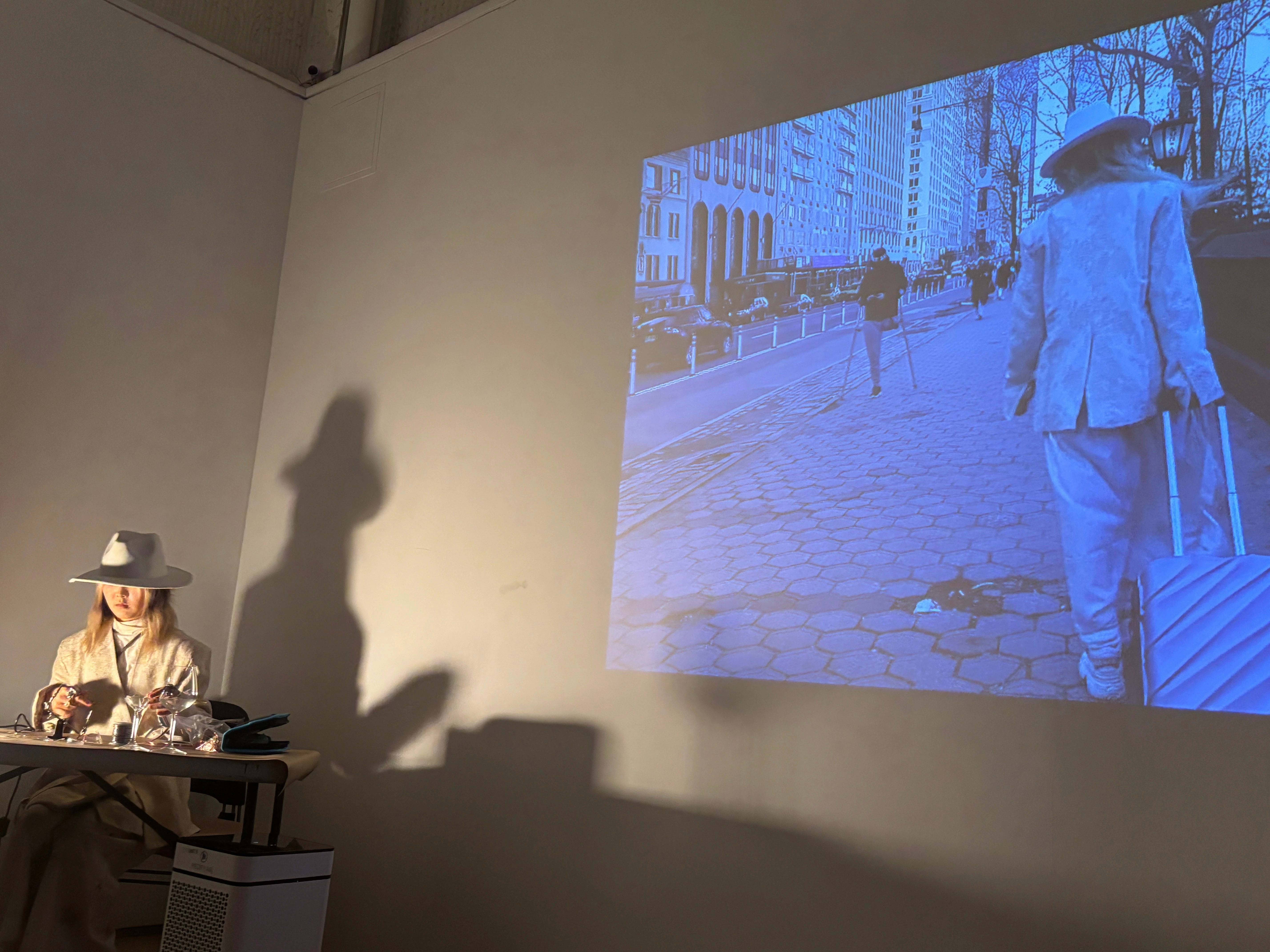 Artist performing with a projection to her right.