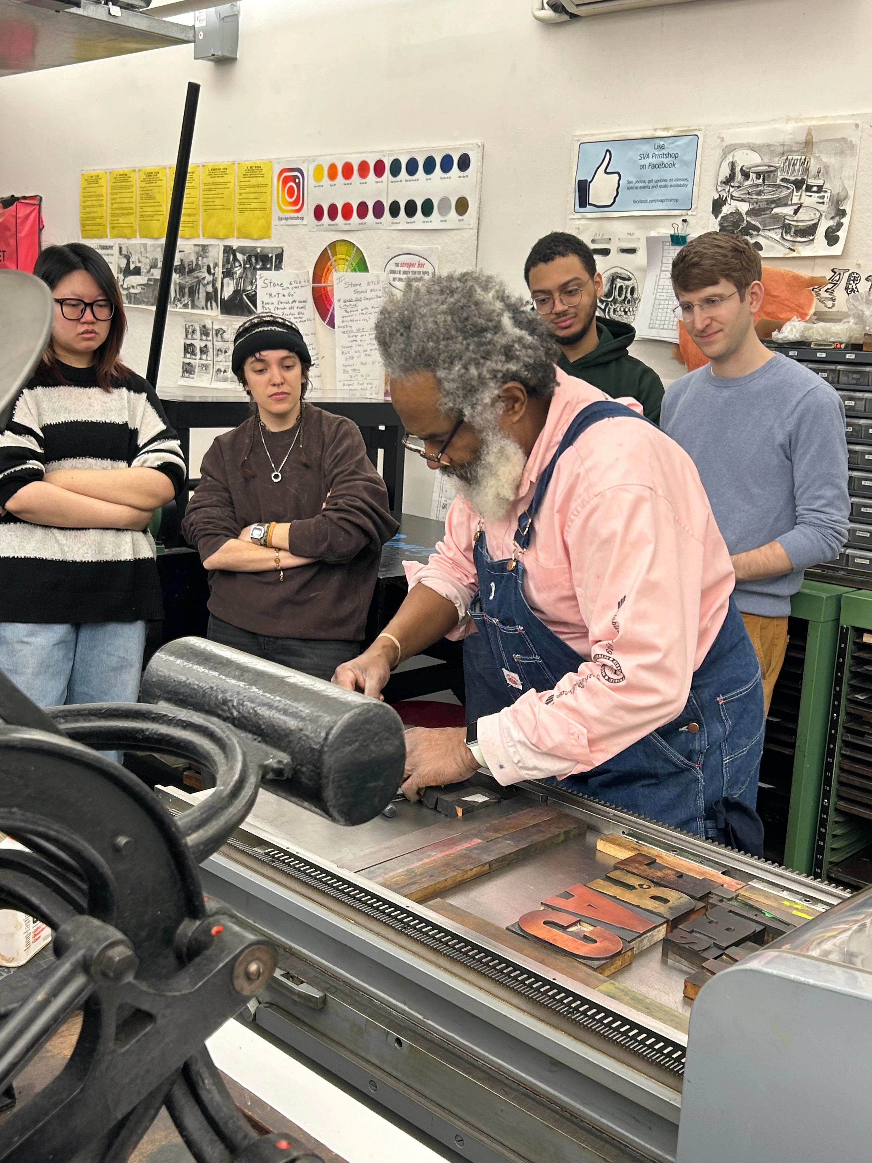 students watching Amos Paul Kennedy, Jr. set up letterpress printing