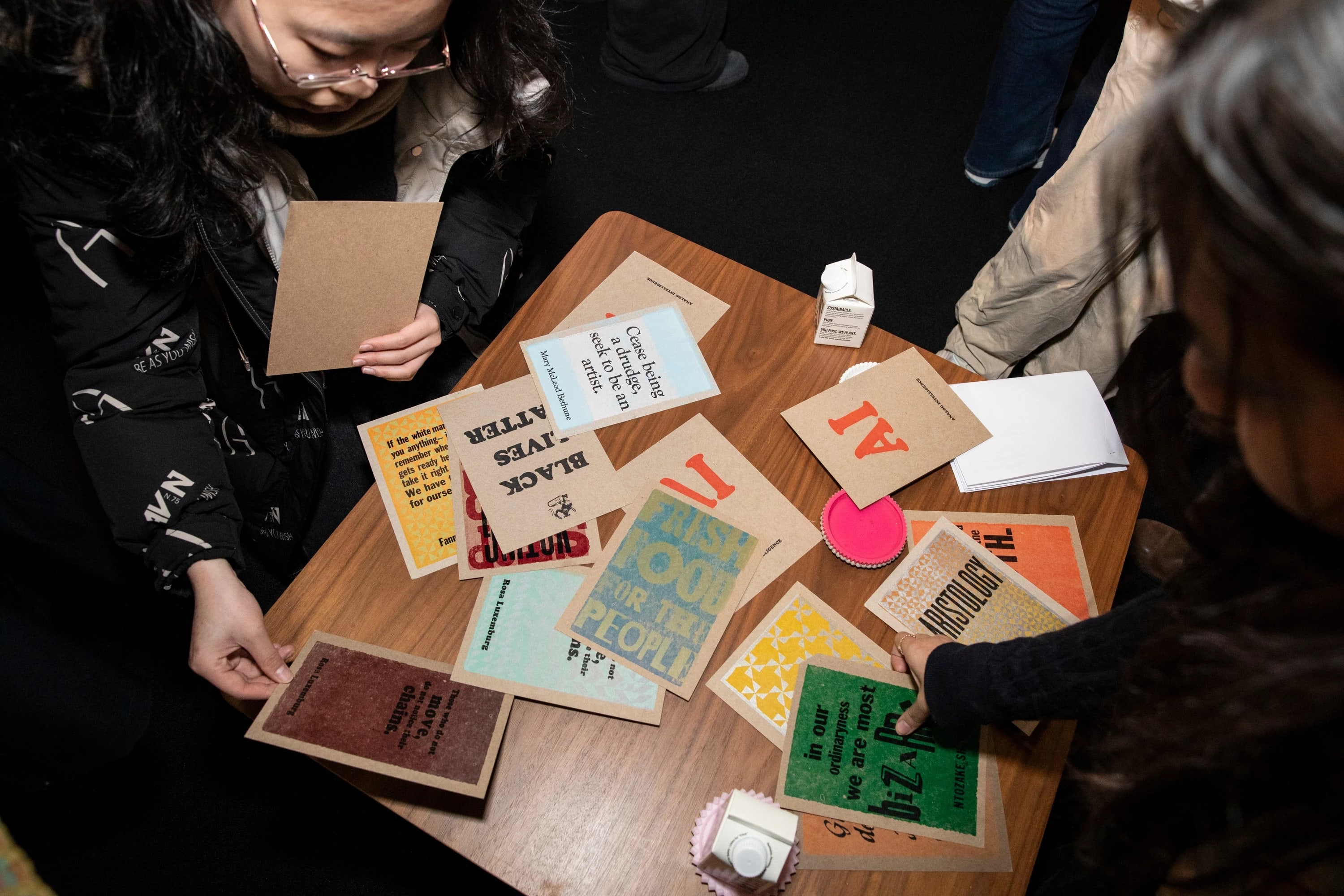 audience members looking at several of Amos' letterpress creations