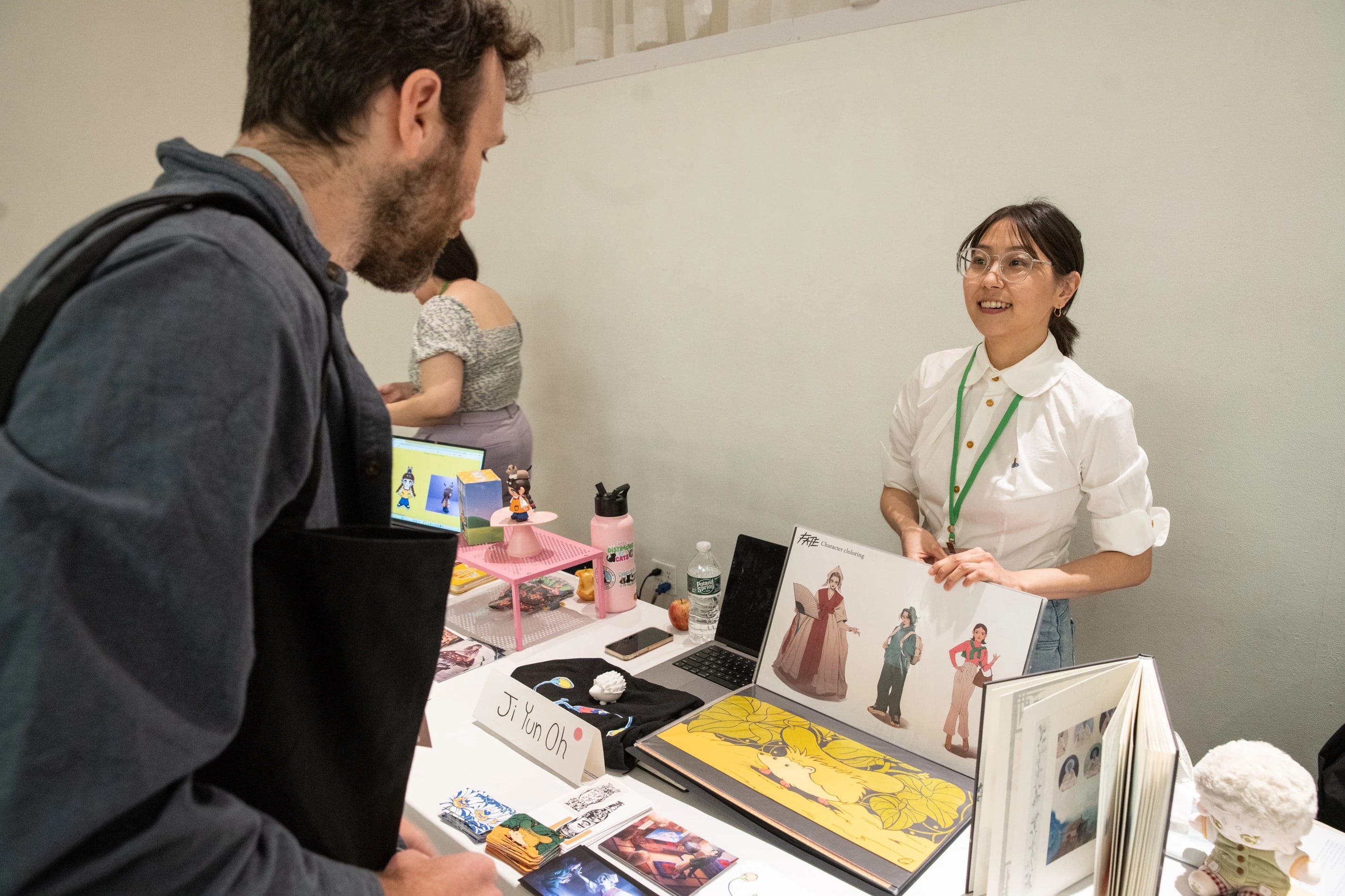 A student chats with a guest about their display of work.