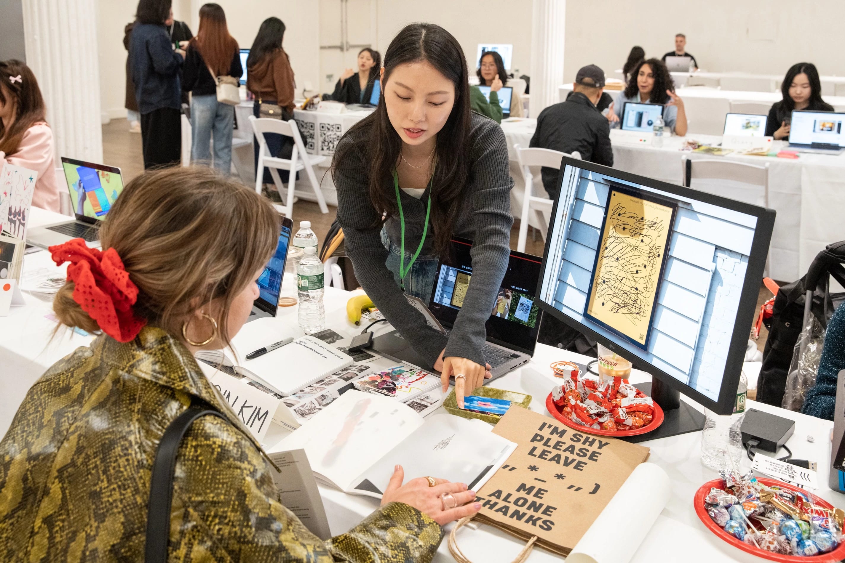 A student chats with a guest about their display of work.