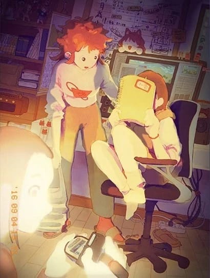 Three crew members, 2 standing and 1 seated in a crowded office setting are gathering together and taking a photo.