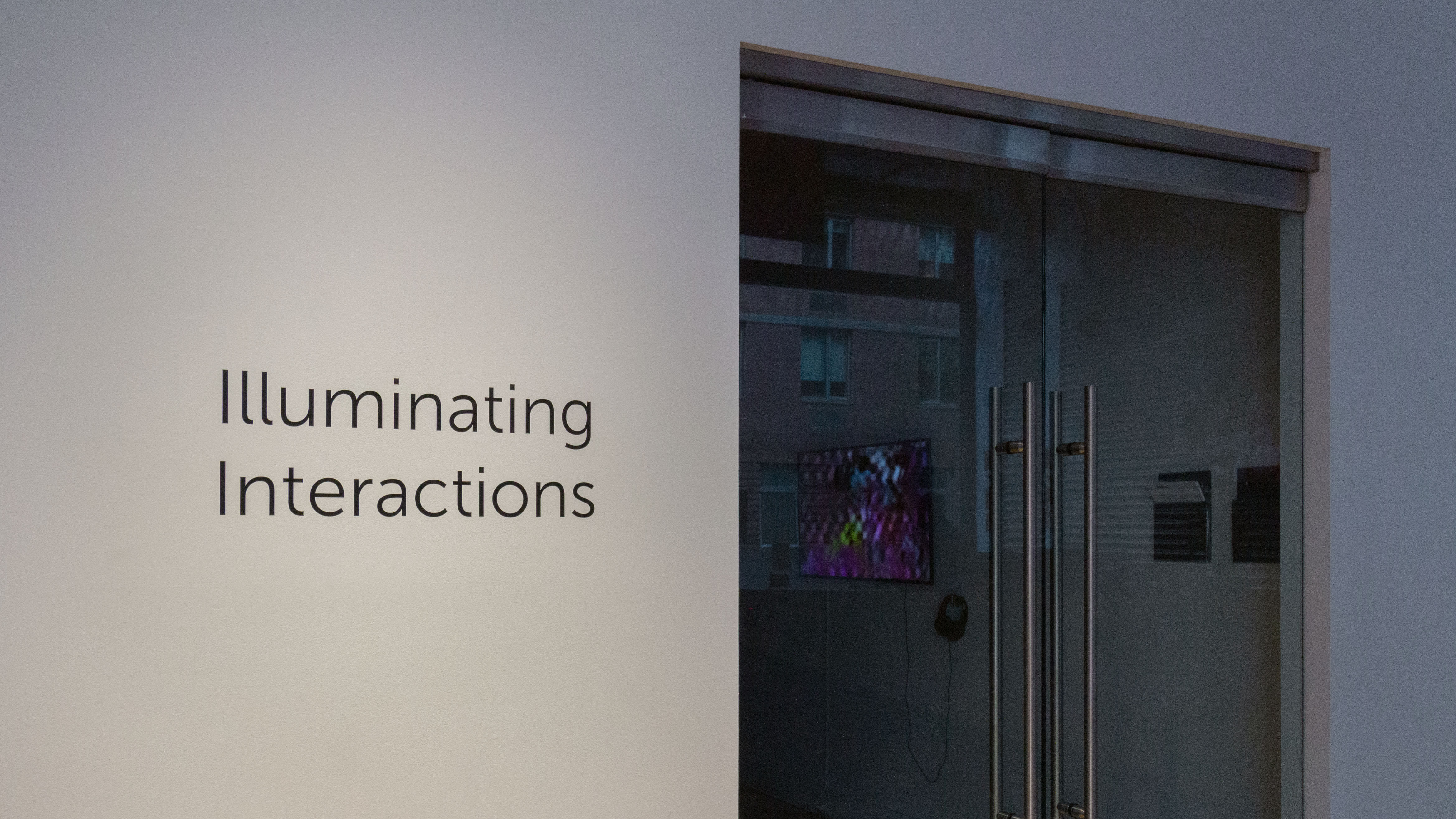 Multiple views of SVA Flatiron Gallery. There are three monitors playing various videos on the wall and an interactive projection.