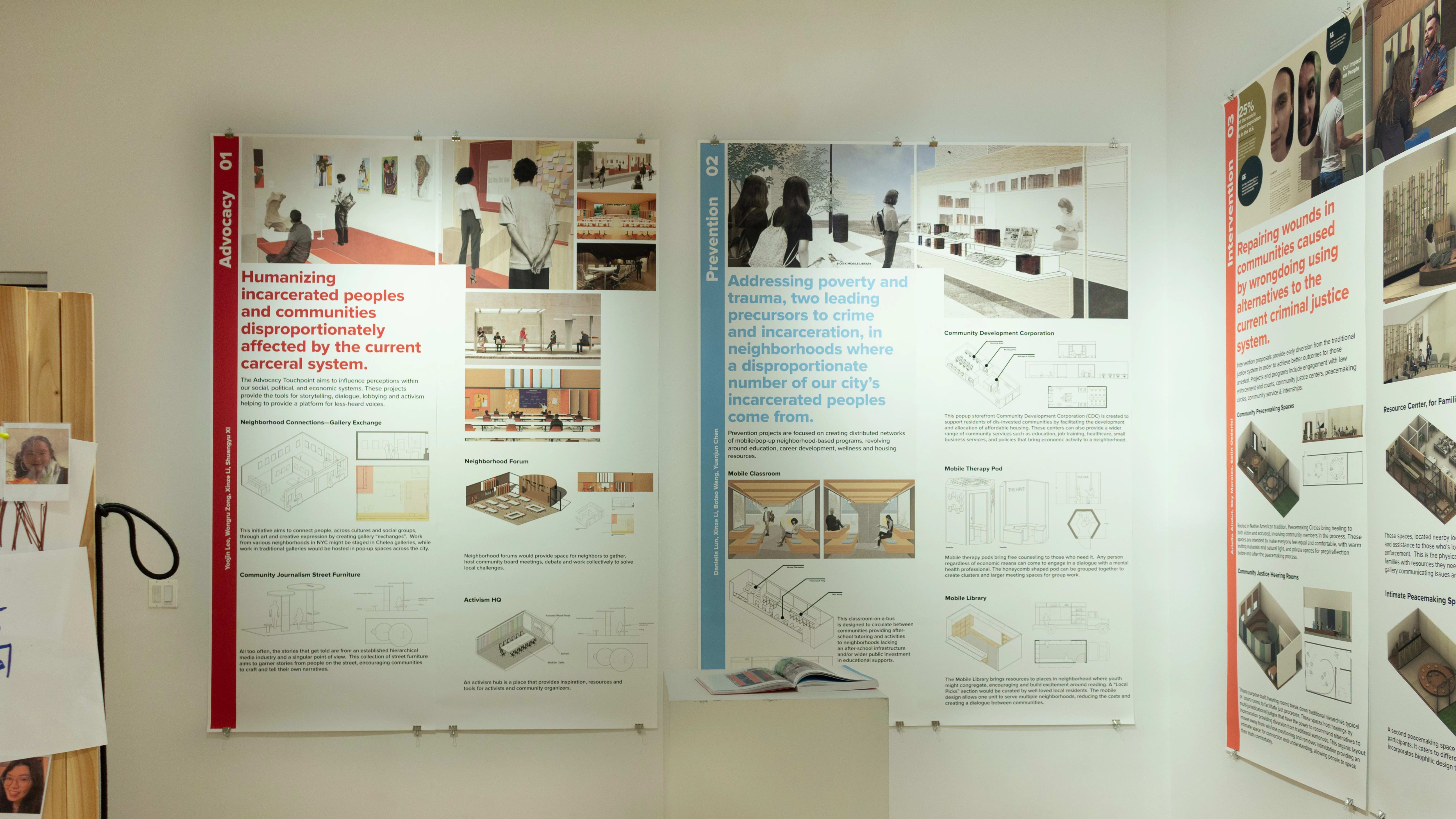 Exhibition view of An Infrastructure for Restorative Justice, featuring wooden sculpture and large posters on the walls.