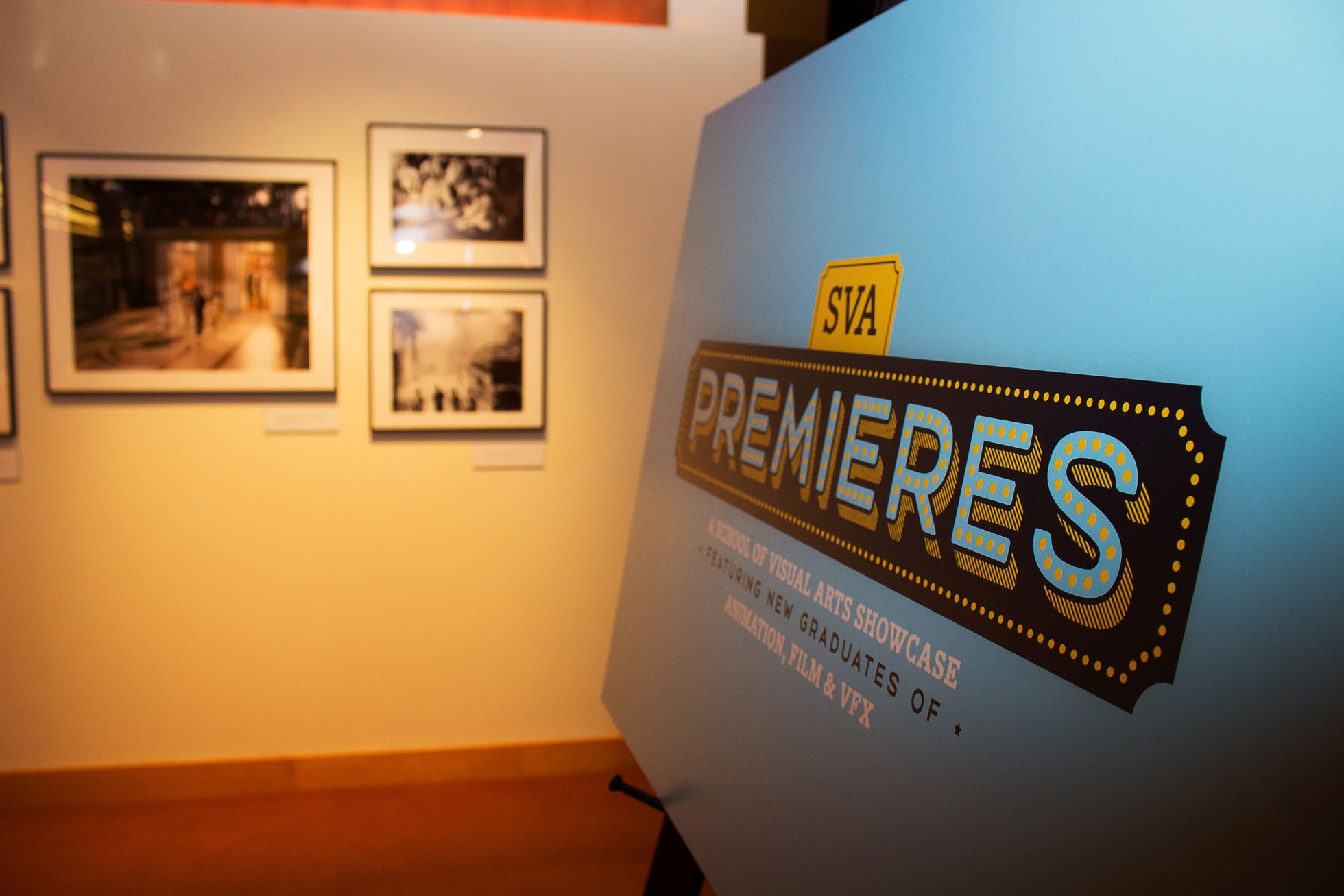 A sign for an art showcase, showing some of the art in the background.