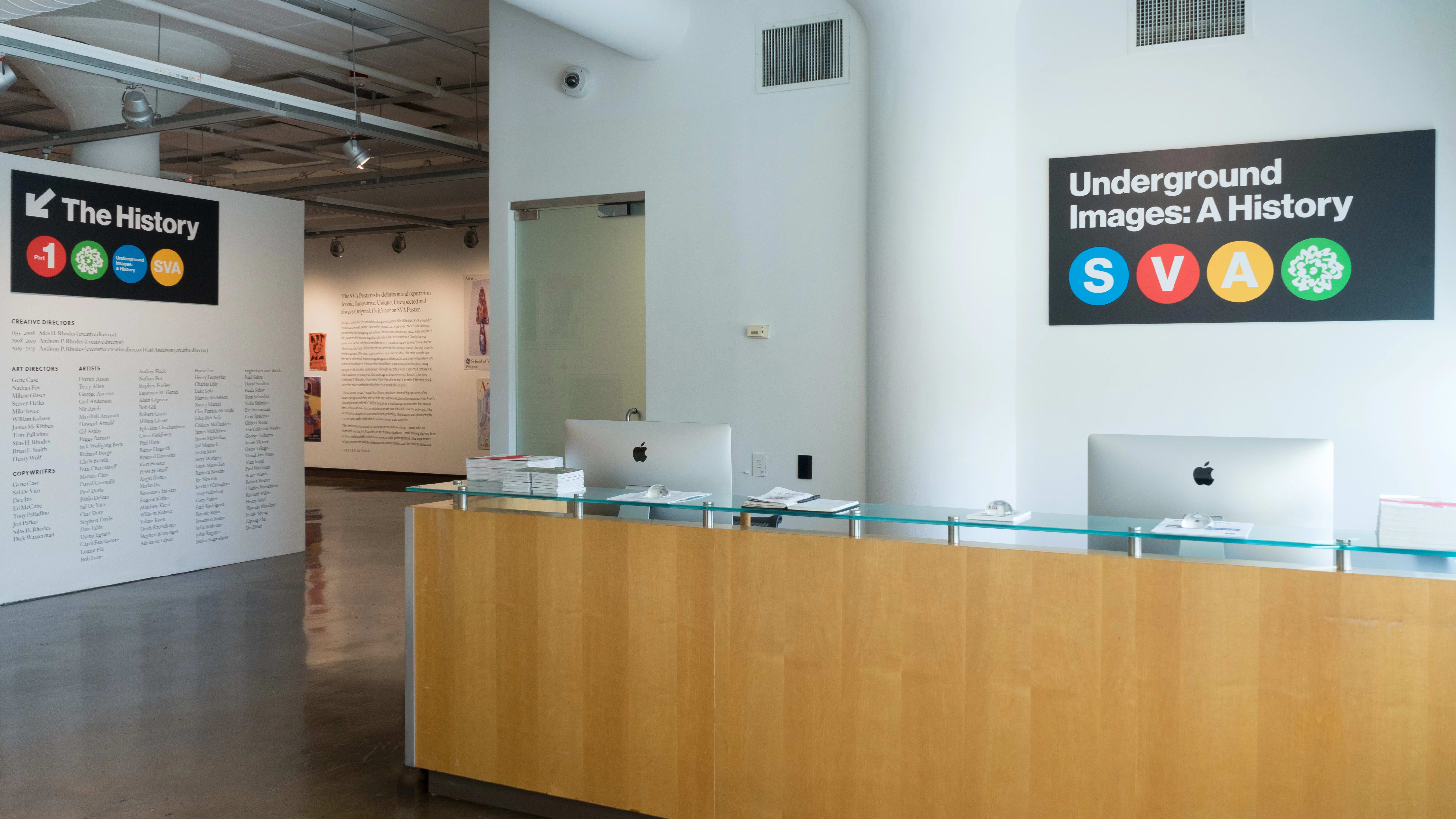 Front desk of art gallery with a poster exhibition on the far left.