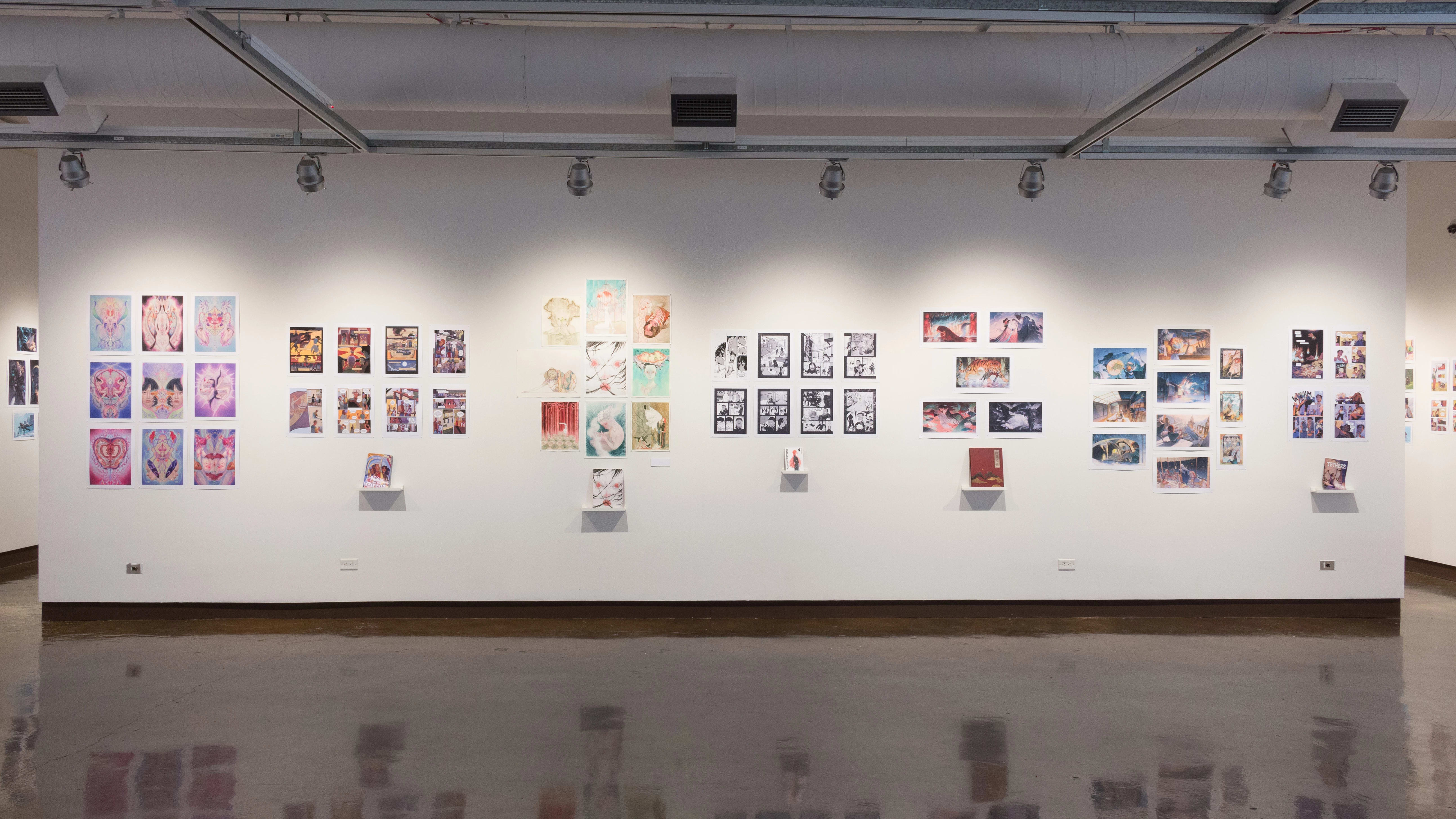 A wall in the first gallery space of the SVA Chelsea Gallery holds seven separate student projects. Each project is displayed as a book on a shelf, with prints from the book hung on the wall above it.