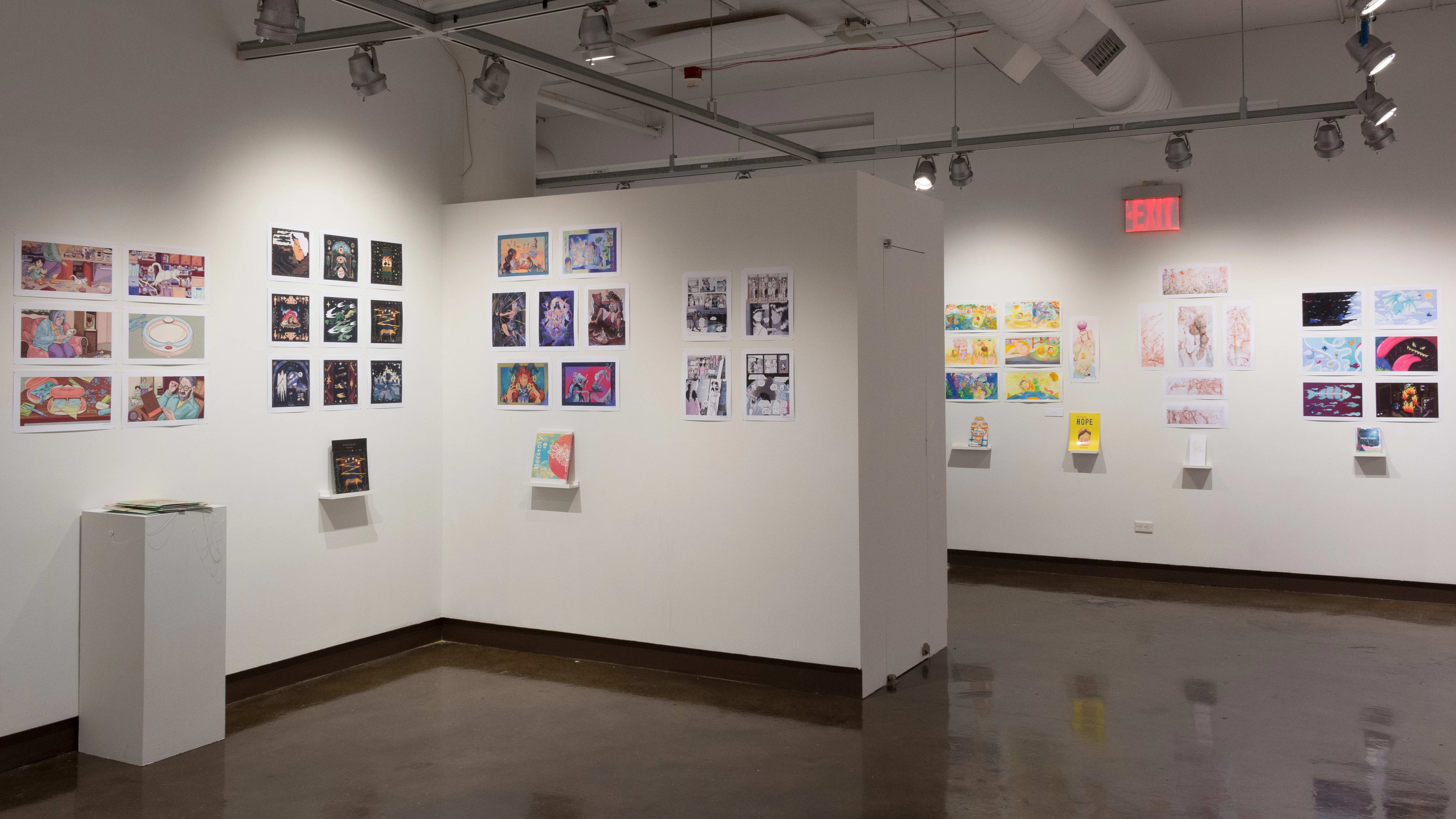 The prints hanging on the walls vary in dimension, style, and color. Books sit on shelves beneath the prints.