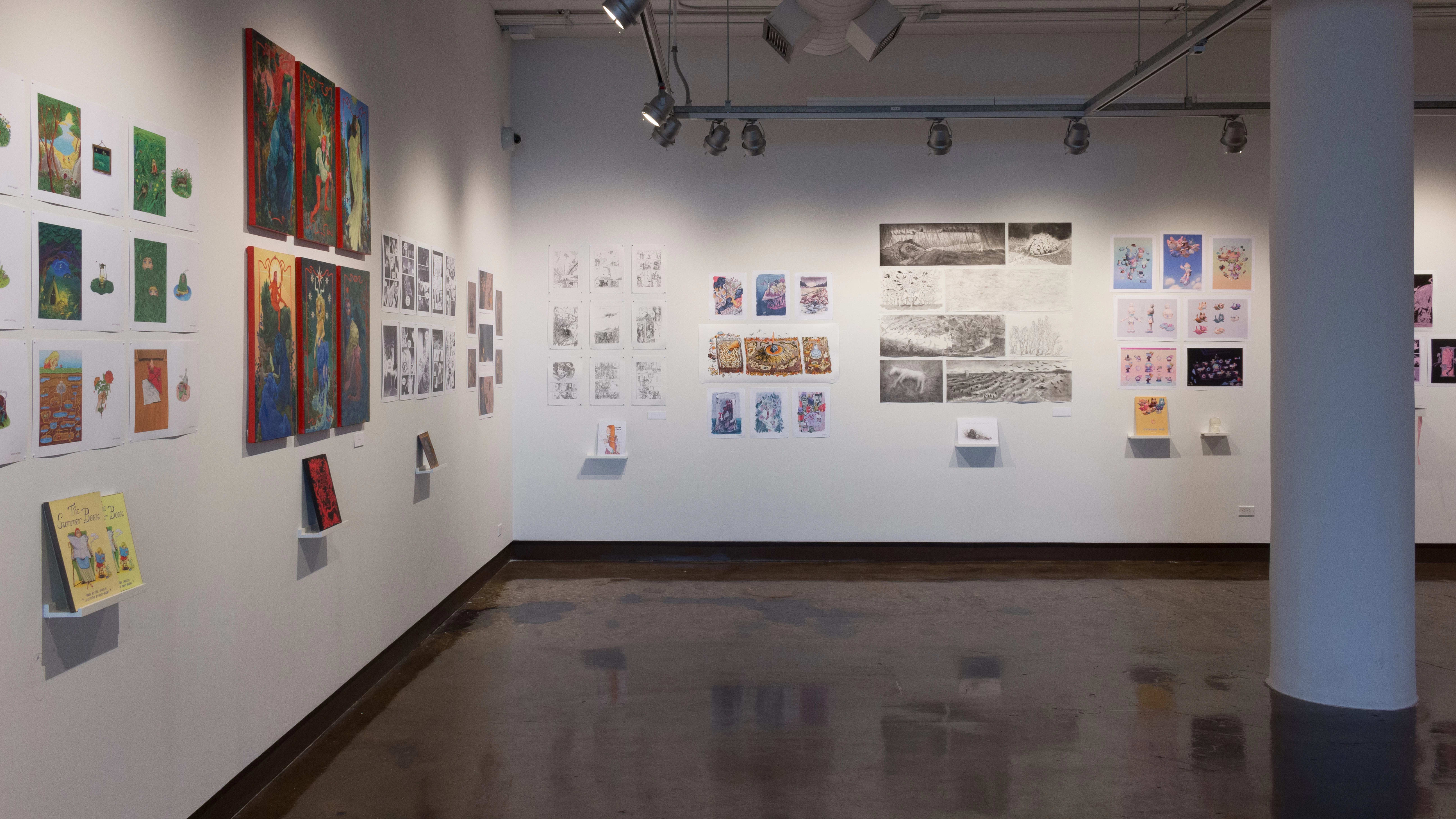 Back in the first gallery space, the prints and originals hanging on the walls vary in dimension, style, and color. Books sit on shelves beneath the prints or originals.