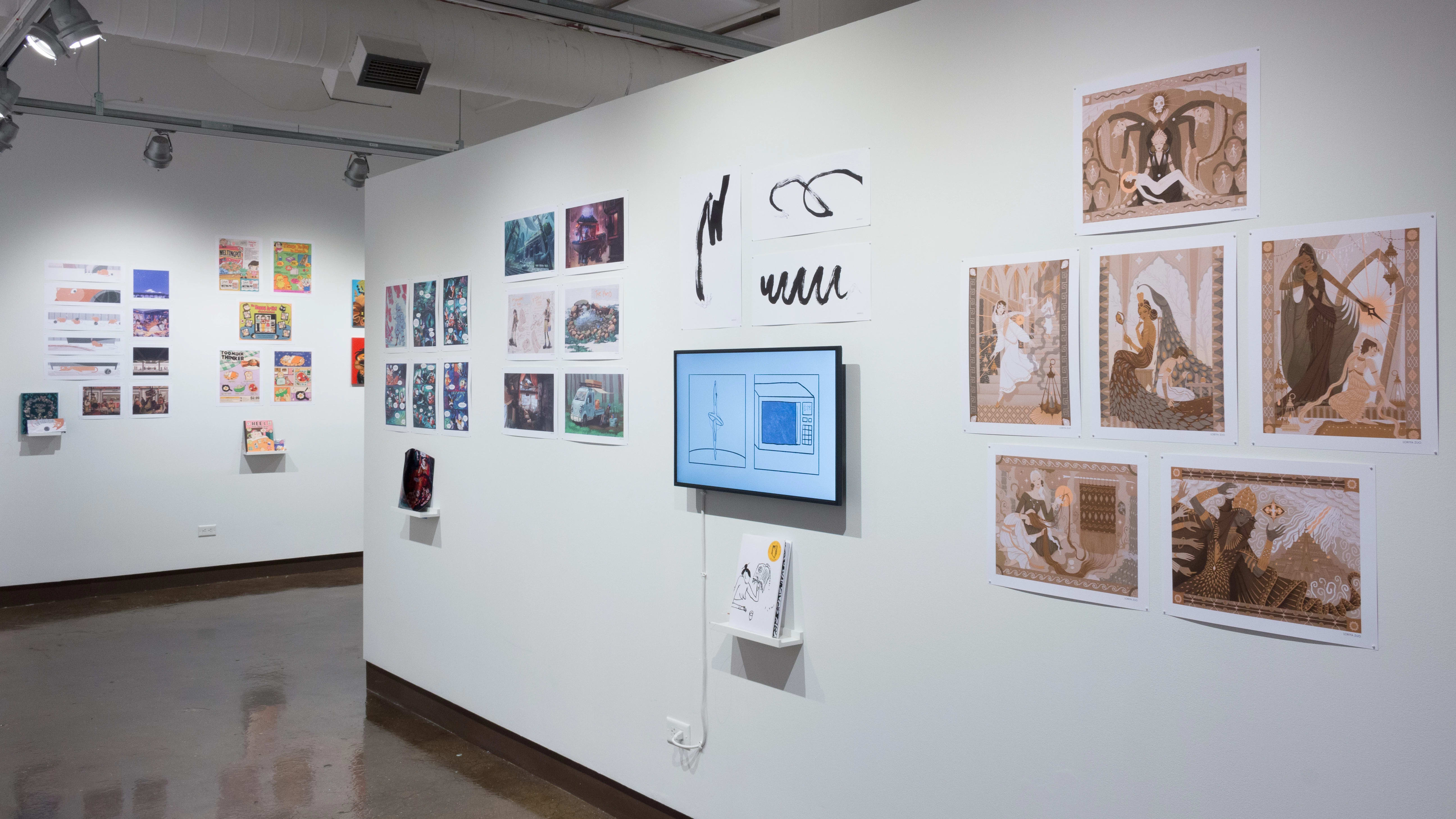 The prints hanging on the walls vary in dimension, style, and color. Books sit on shelves beneath the prints and a monitor displays animations.