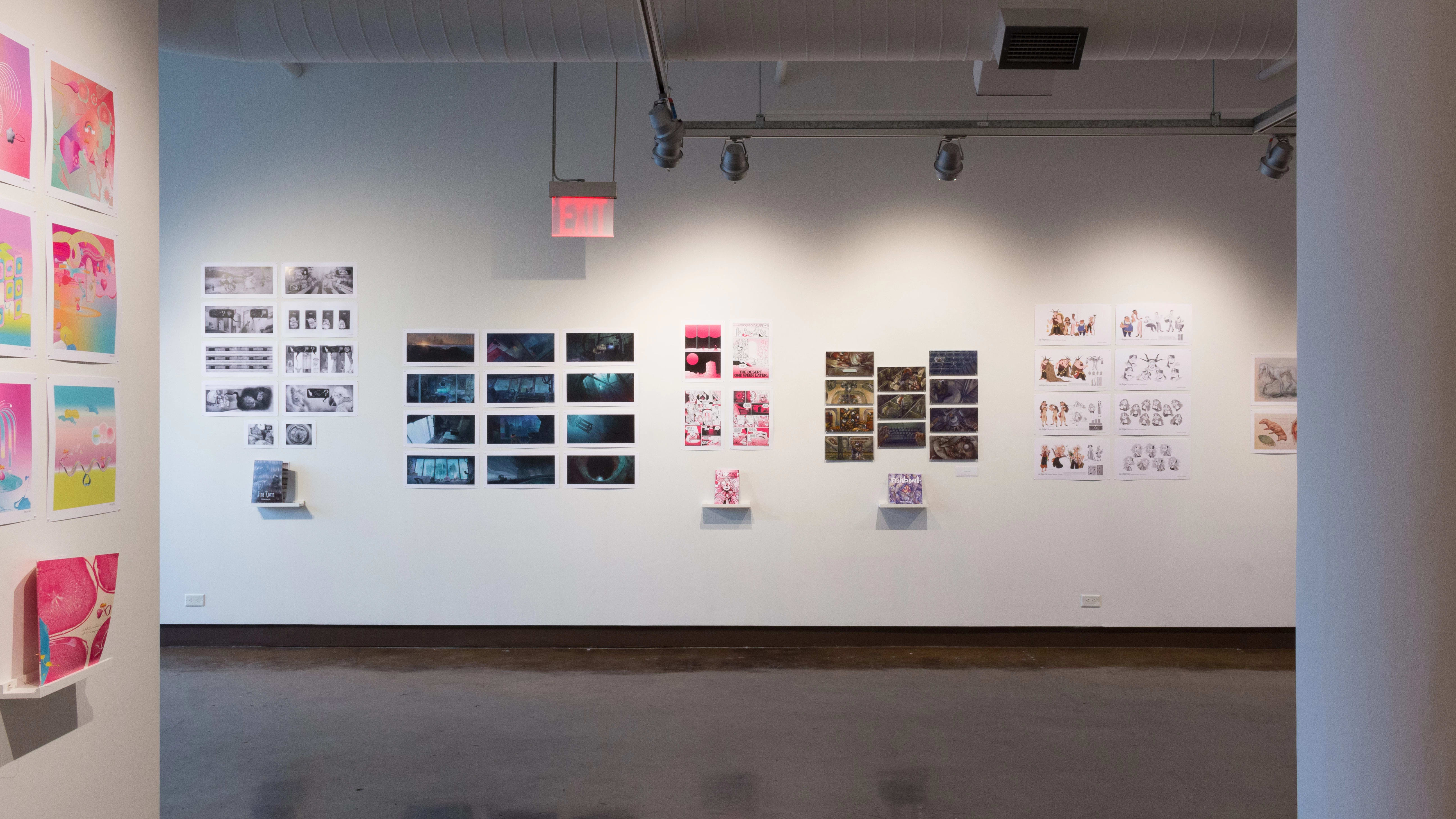 Prints, originals, and books are all displayed on a wall of gallery one.