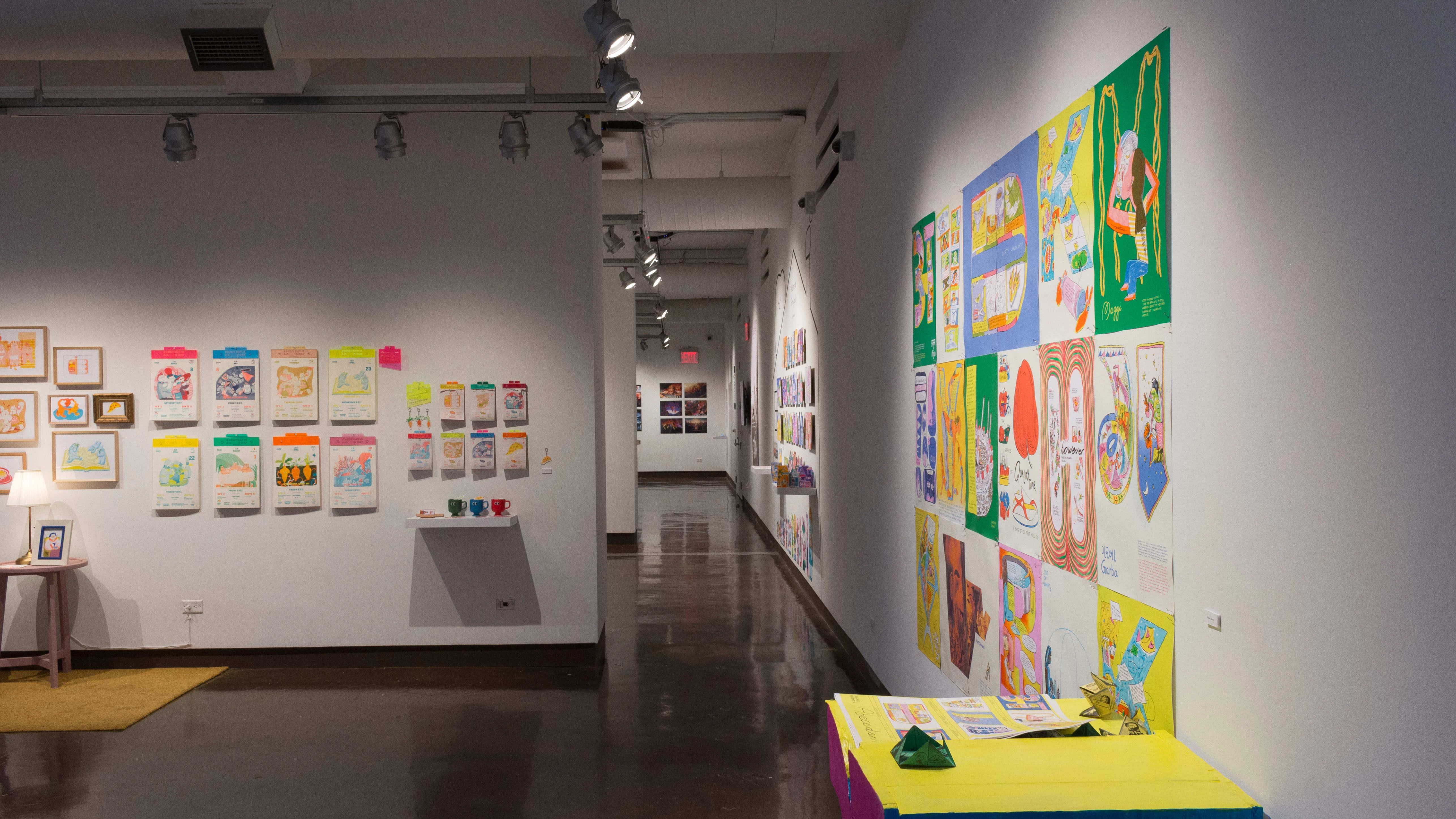 An image taken from gallery one shows the right hallway leading into the far-side wall of gallery four with one installation of wall-mounted illustrations.