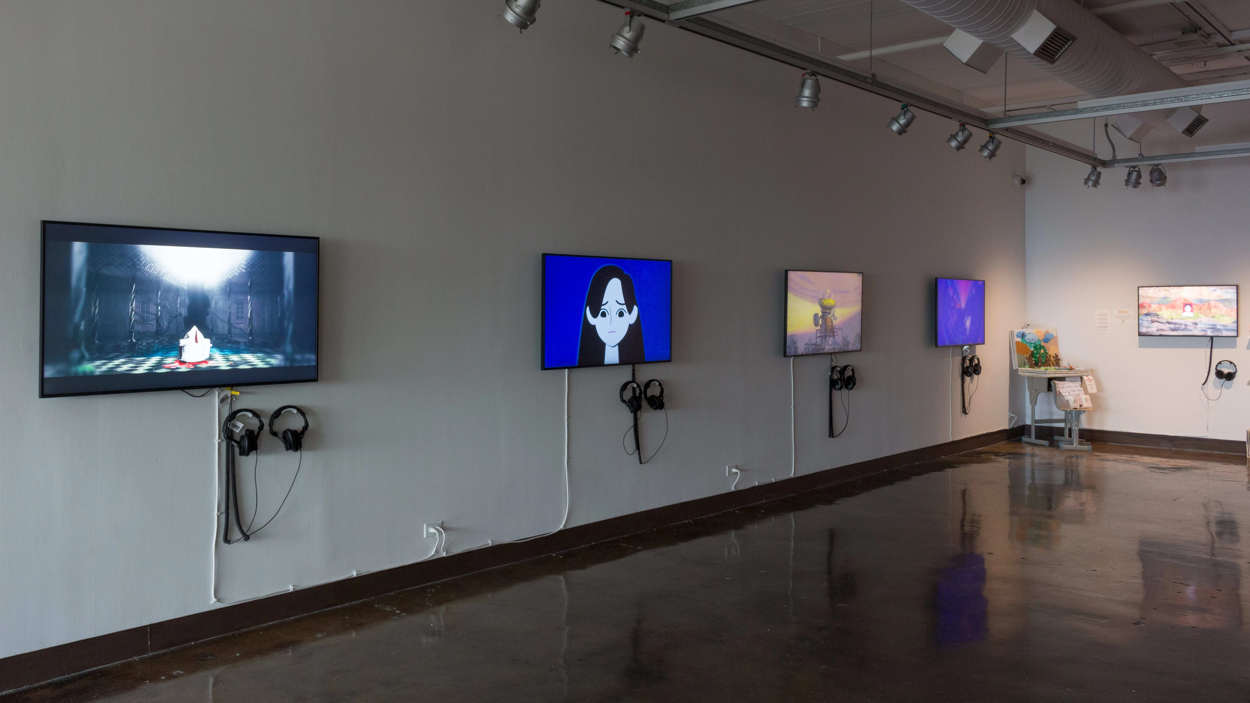 Installation image showing four monitors along a wall playing videos of various lengths in reels.
