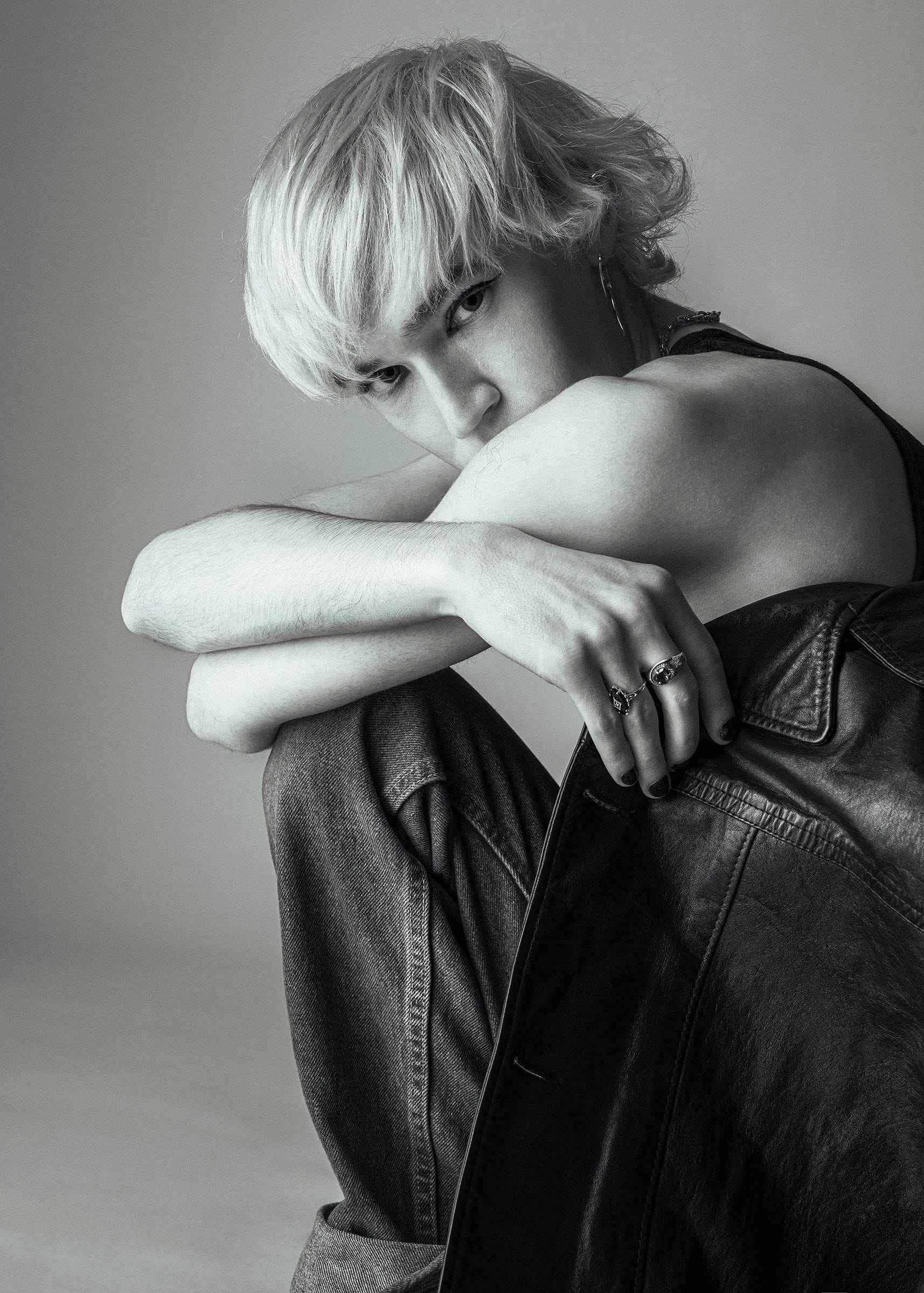 A black and white portrait of Stephen crouched down