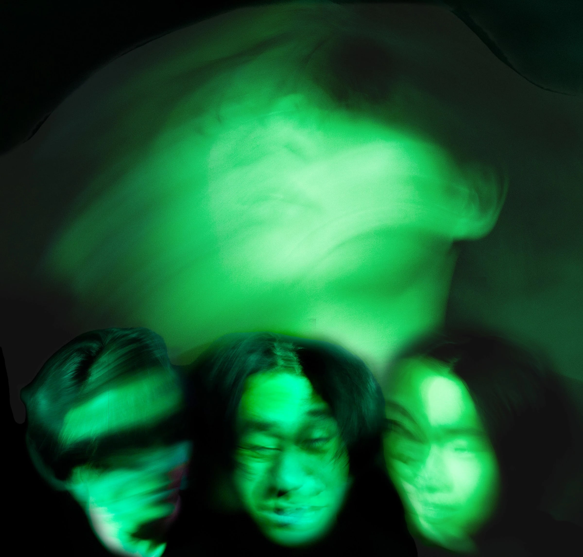 a black and green photo of blurred faces
