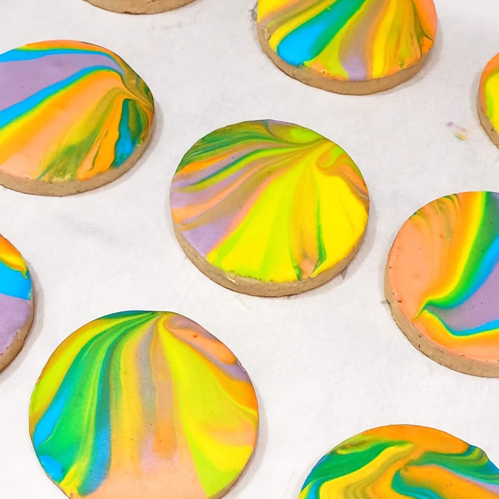 A photograph of several rainbow-frosted cookies.