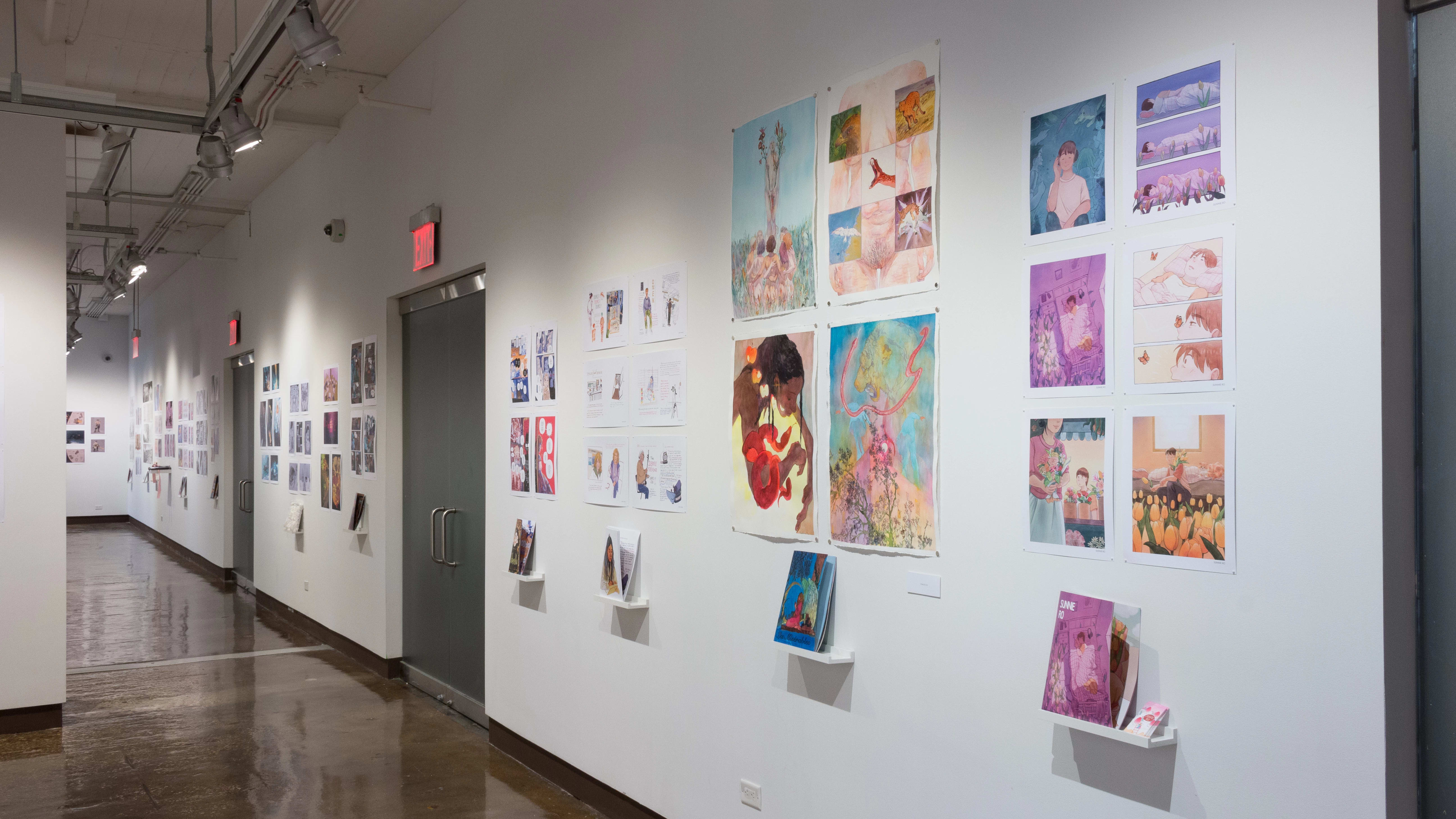 The prints hanging on the walls vary in dimension, style, and color. Books sit on shelves beneath the prints.