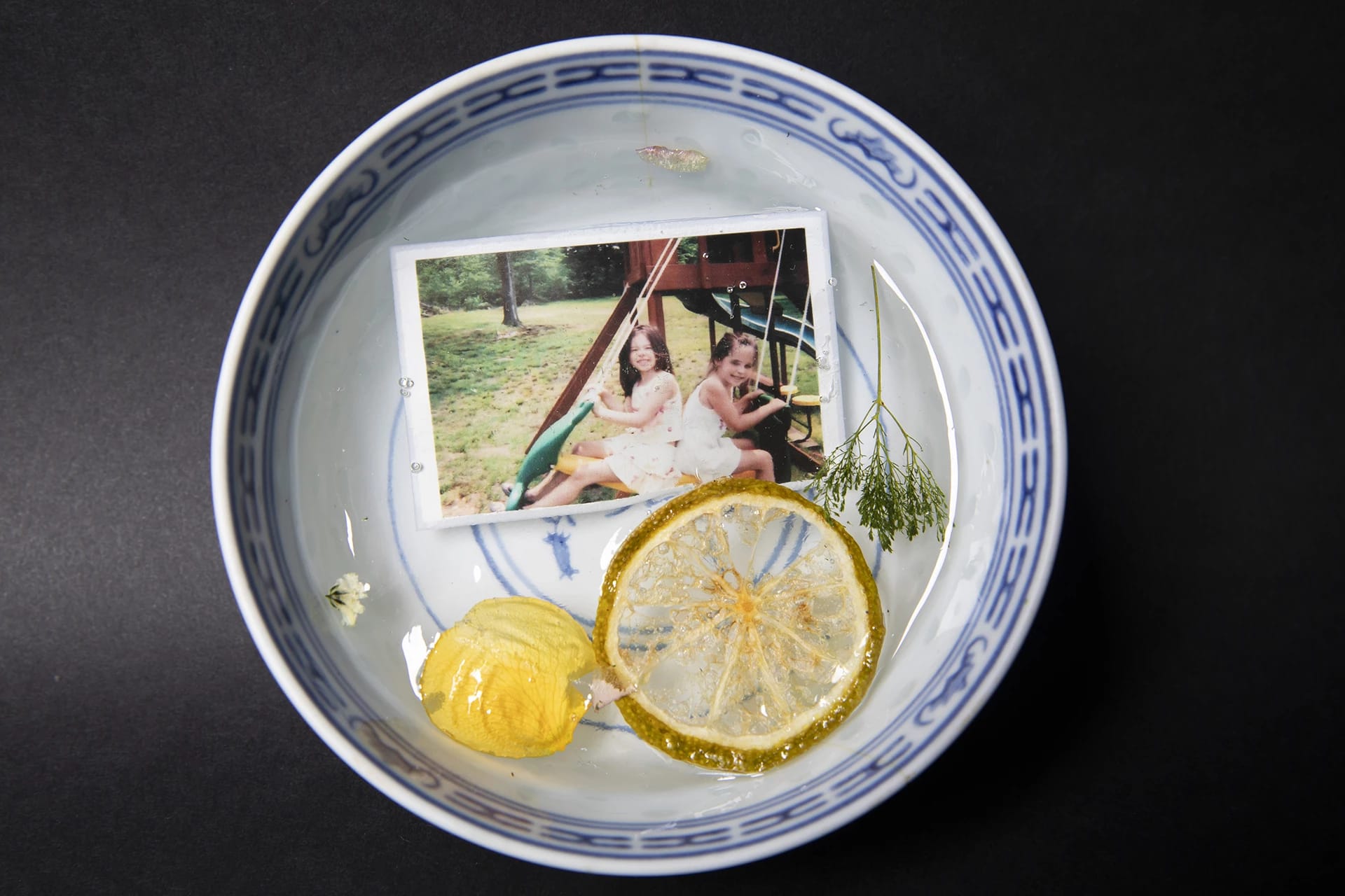 A person naked, bent over in a bed with a rock balancing on their back.