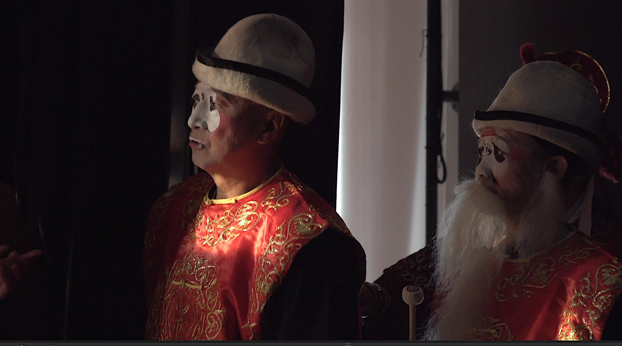 Portrait of two Beijing Opera actors, back stage & in costume looking left onto the stage