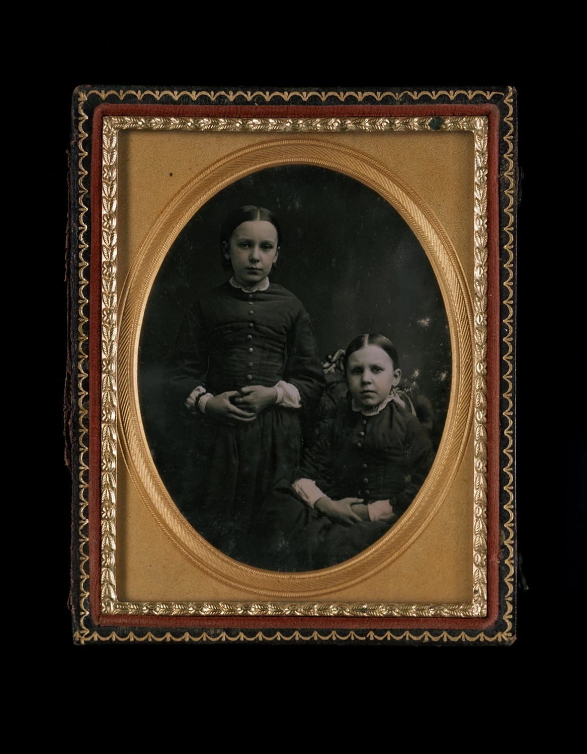 A photo of a framed daguerrotype featuring two young girls