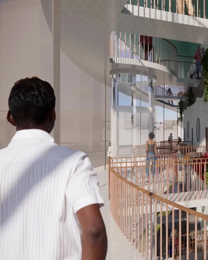 A man in a white shirt looks on at a courtyard within a housing complex.