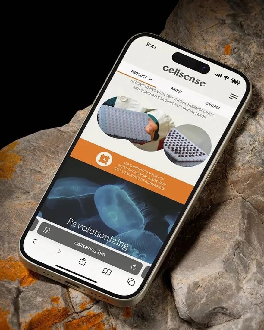  A smartphone rests on a rock, displaying its screen in a natural outdoor setting.