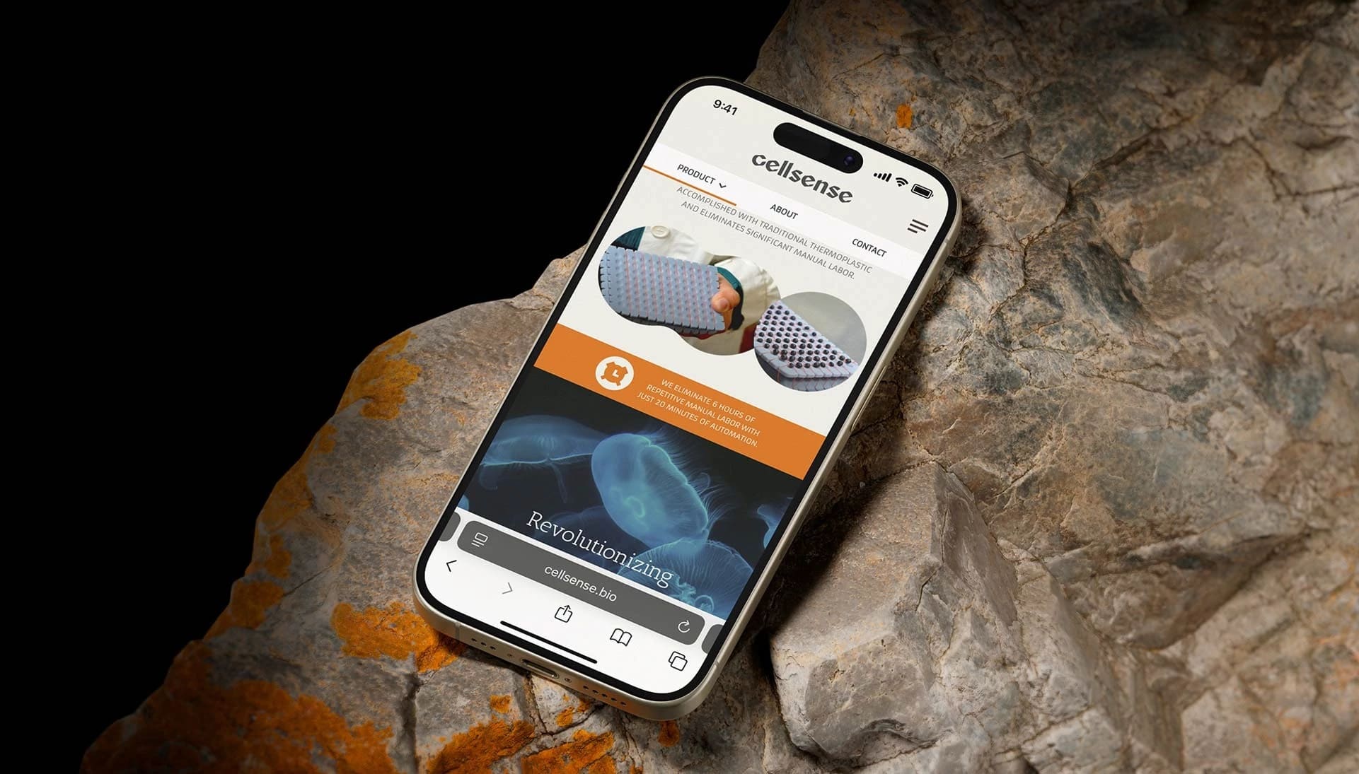  A smartphone rests on a rock, displaying its screen in a natural outdoor setting.