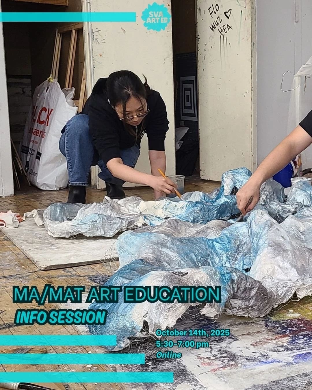 Two people kneel over papier-mâché forms painted with blue, silver and white paint.