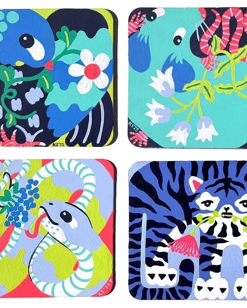 Four coasters featuring various animals surrounded by colorful flowers.