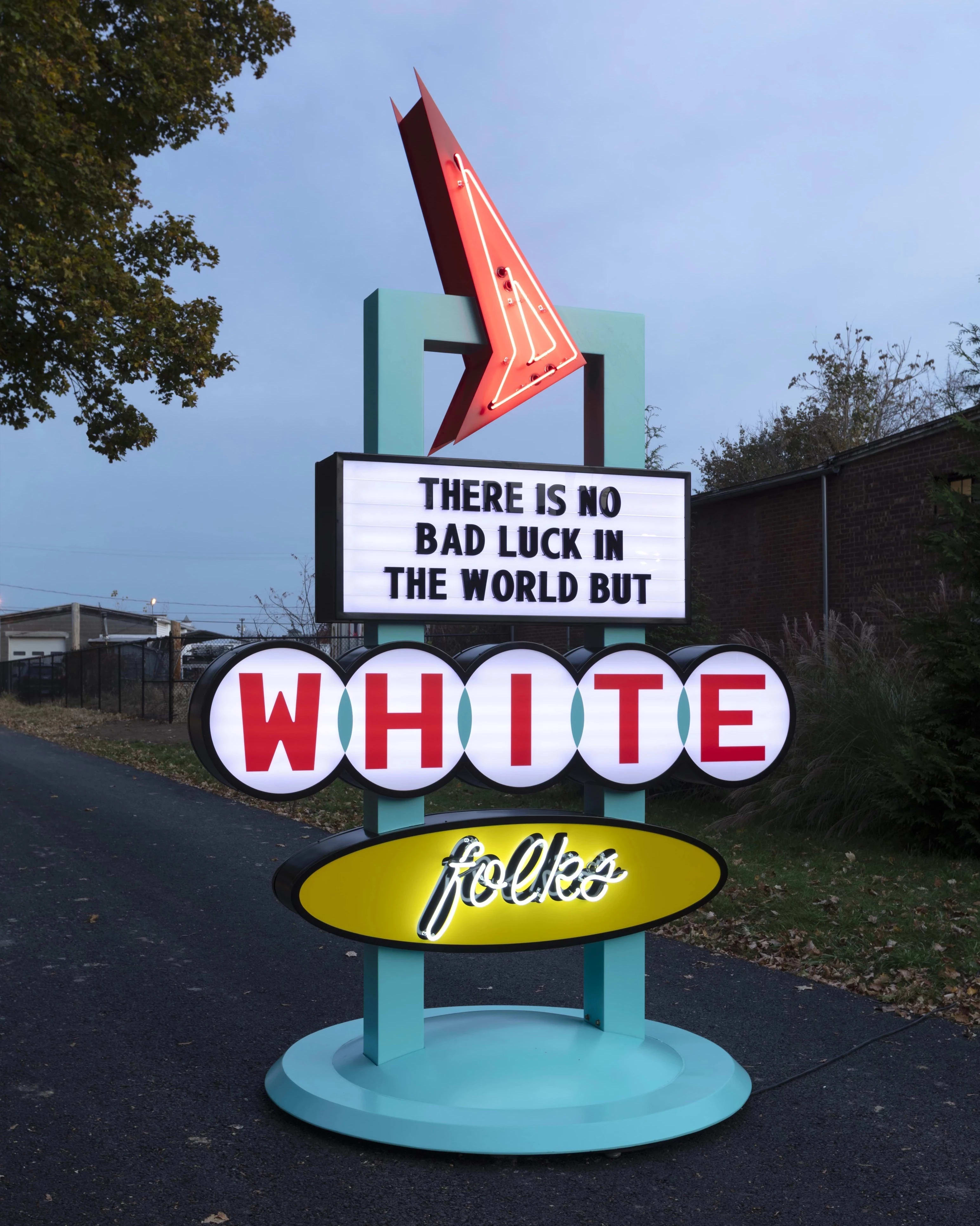 Picture of a large neon sign that reads "There is no bad luck in the world but white folks"