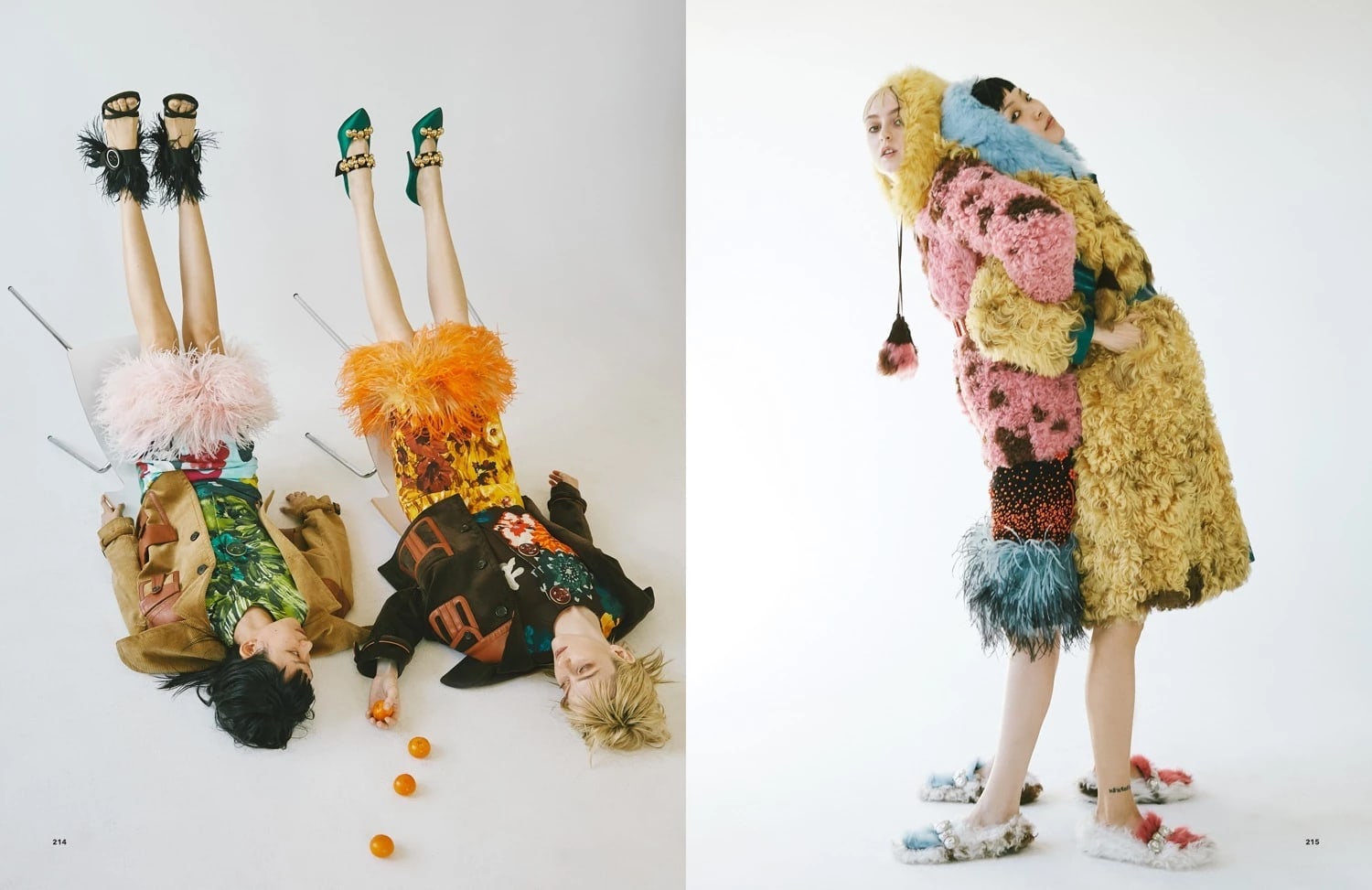 Two images of two models dressed in fluffy colorful clothing that resembles flowers. In the first image they're both laying on the floor with their legs up, looking at mandarin oranges scattered on the floor. In the second one they are standing back to back, leaning on each other and looking at the camera. 