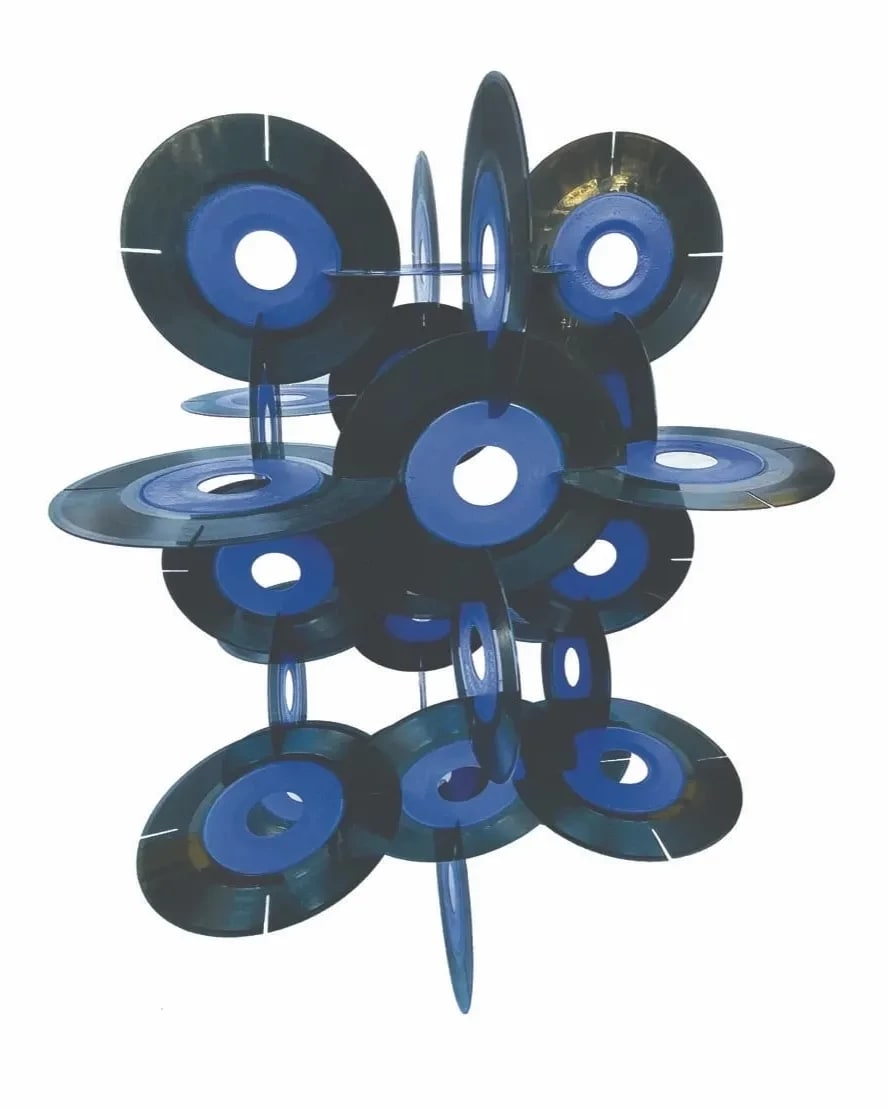 A sculpture made of numerous interlocking 7-inch vinyl records with blue labels. 