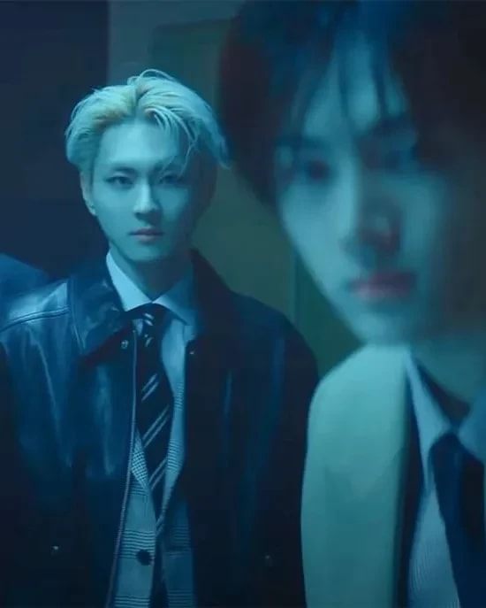 Two male kpop idols look at the viewer with a blue tone over the image.