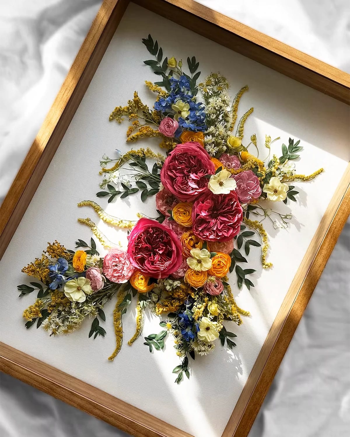Preserved flowers placed in a wooden picture frame